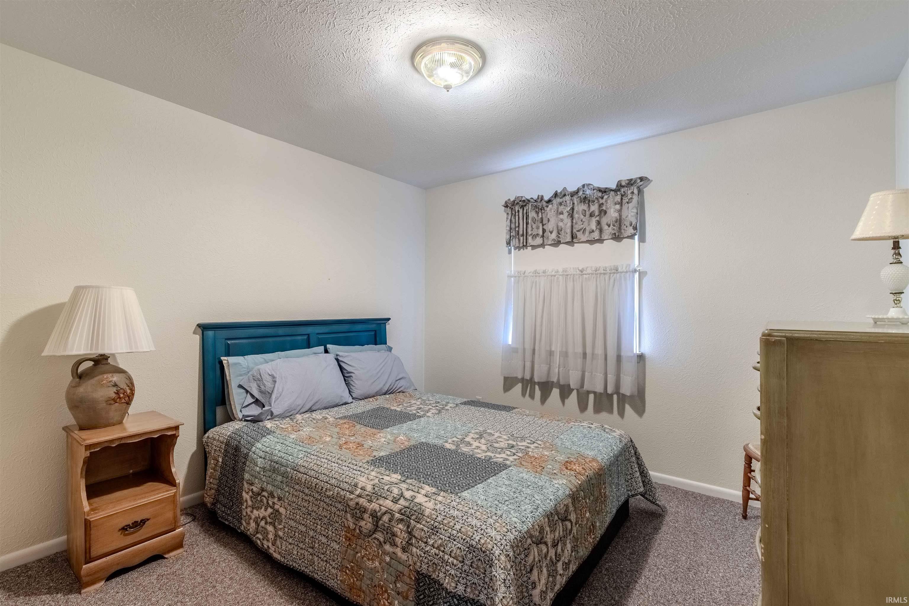 Bedroom featuring a textured ceiling and carpet floors