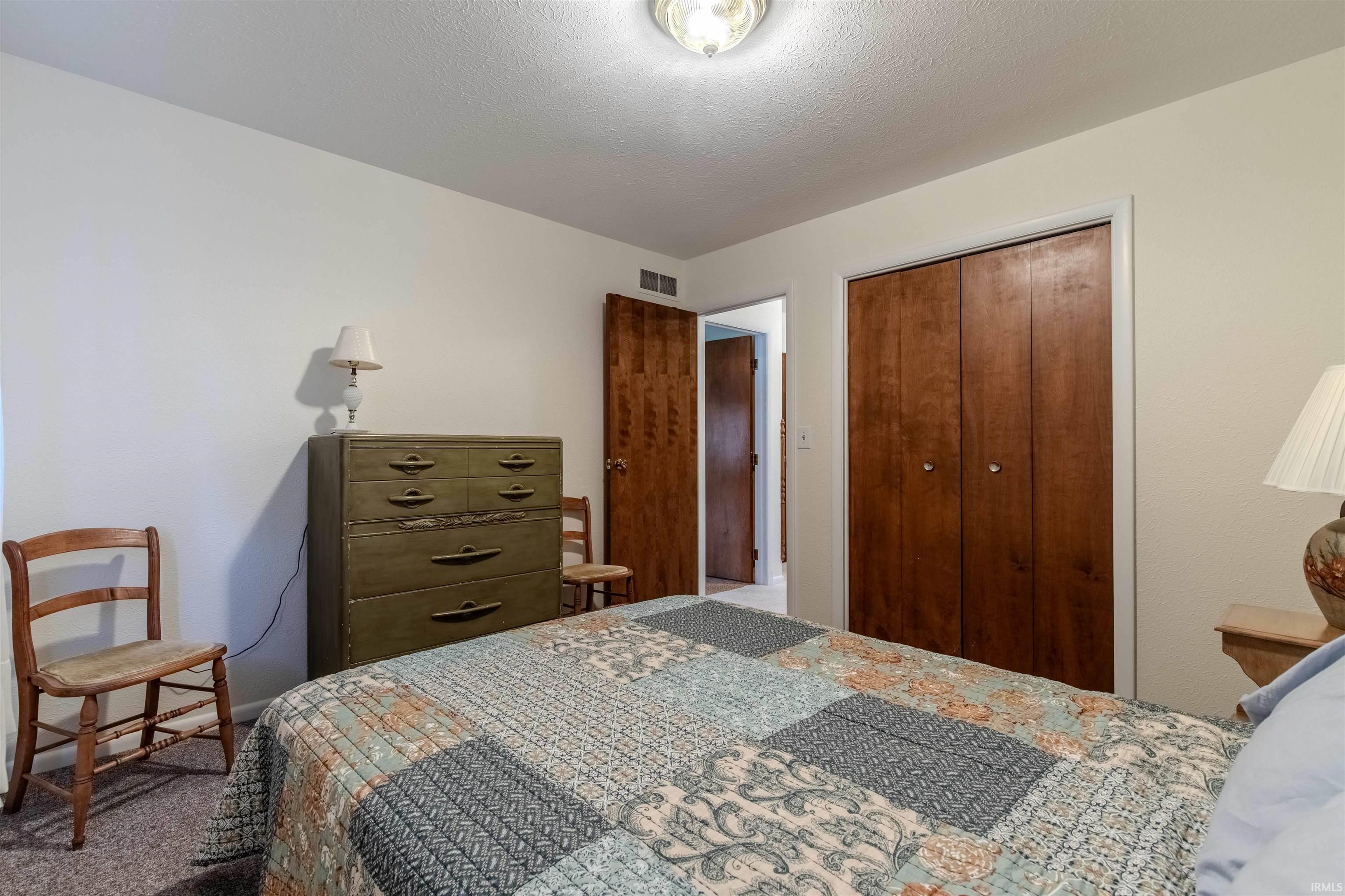 Bedroom featuring a closet and a textured ceiling