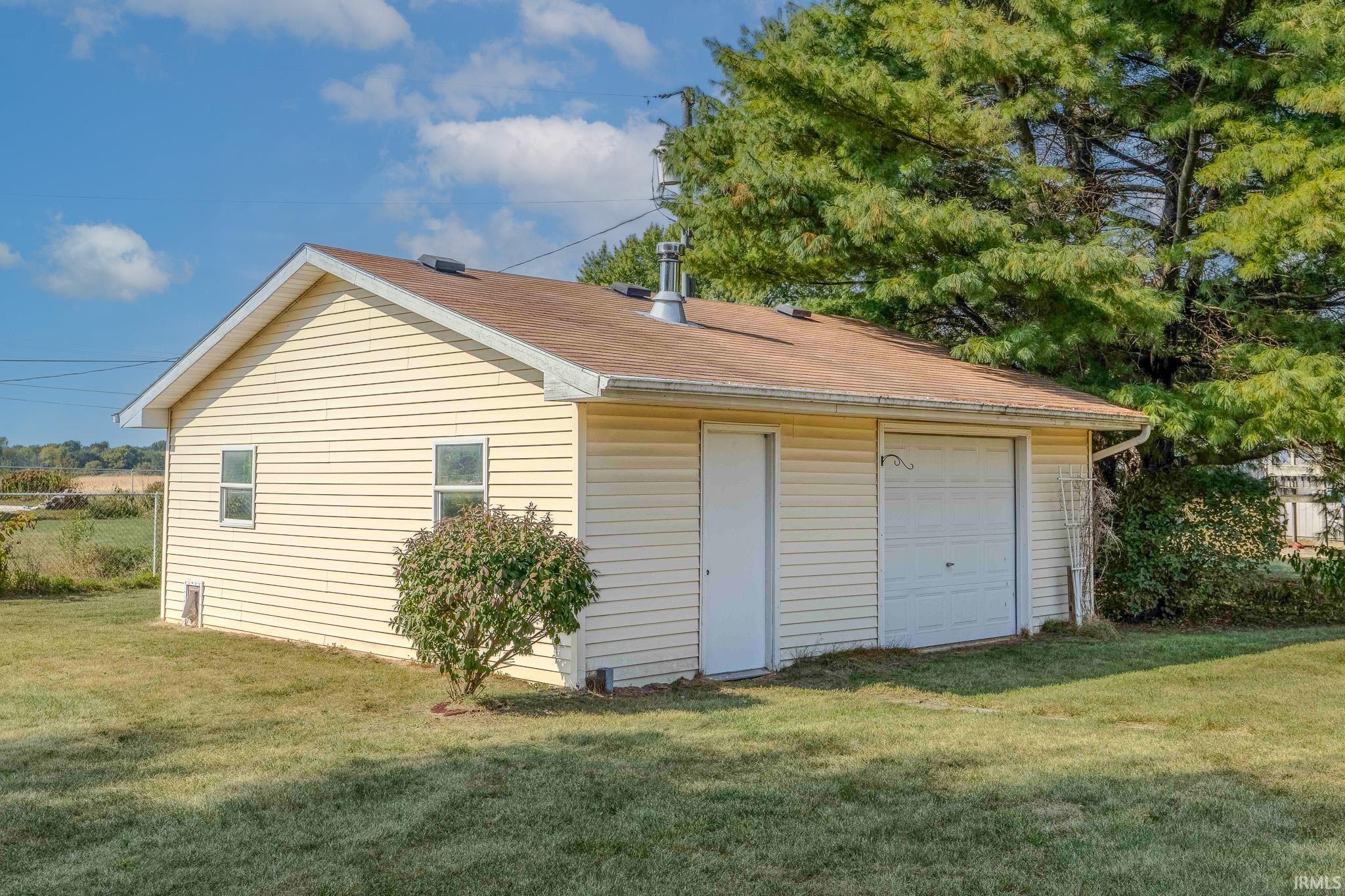 Rear view of property with a yard and a garage