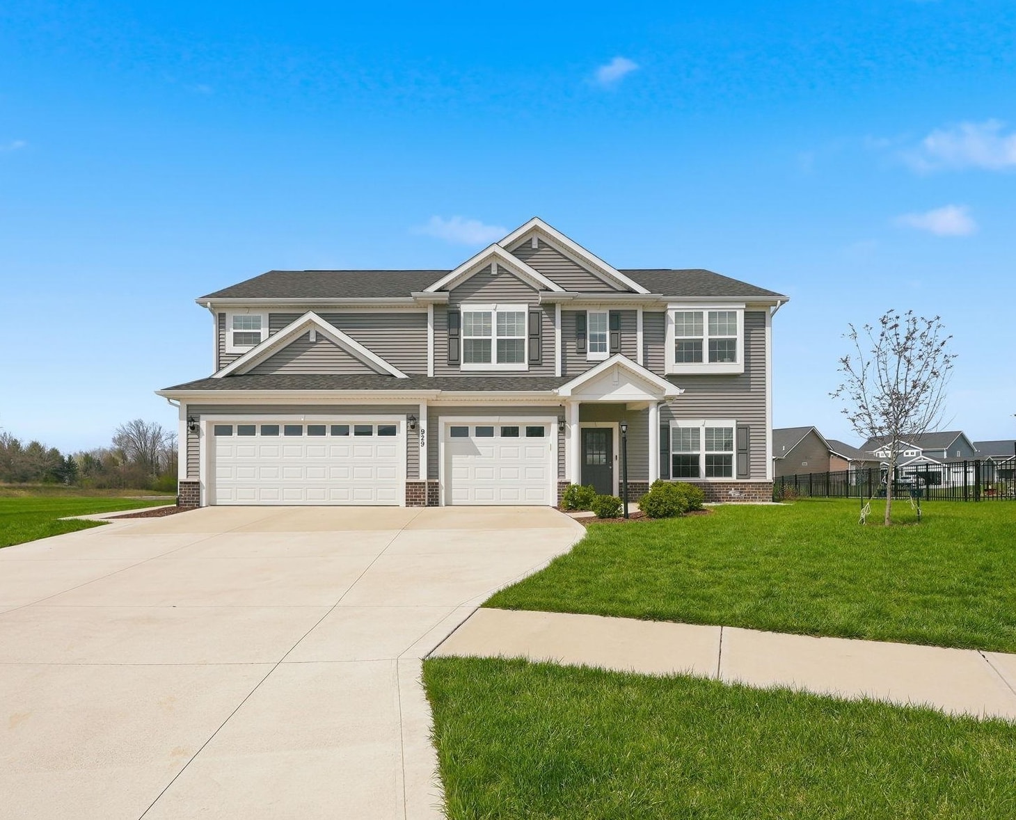 View of front facade with a front yard, concrete driveway, brick siding, and an attached garage
