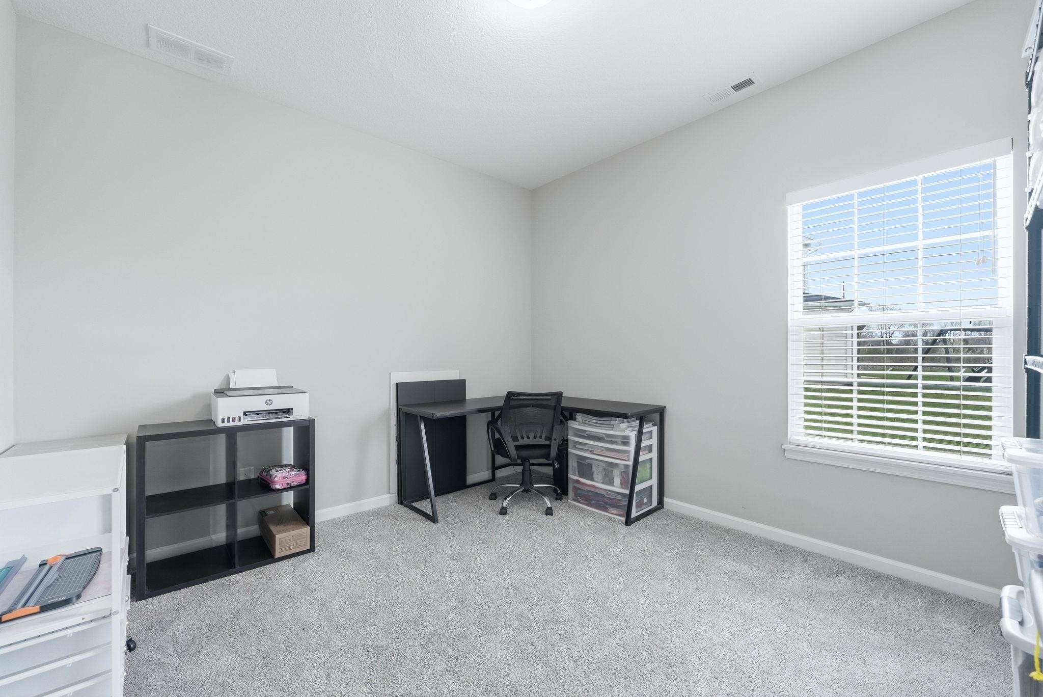 Home office featuring light colored carpet and baseboards