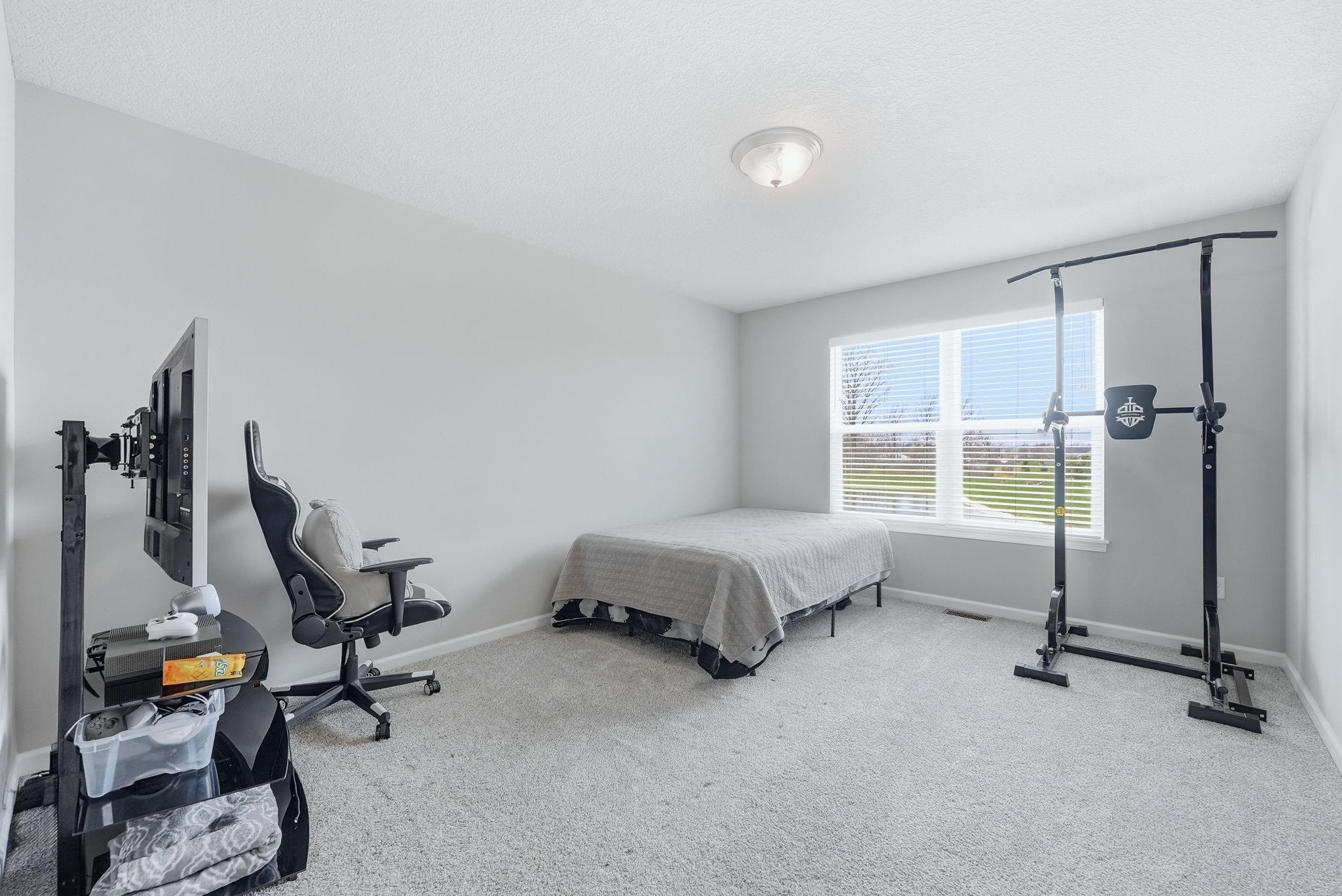 Bedroom featuring baseboards and light colored carpet