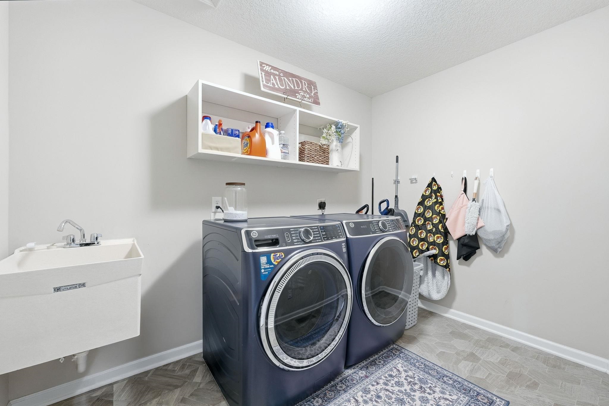 Laundry area featuring a textured ceiling and washing machine and dryer