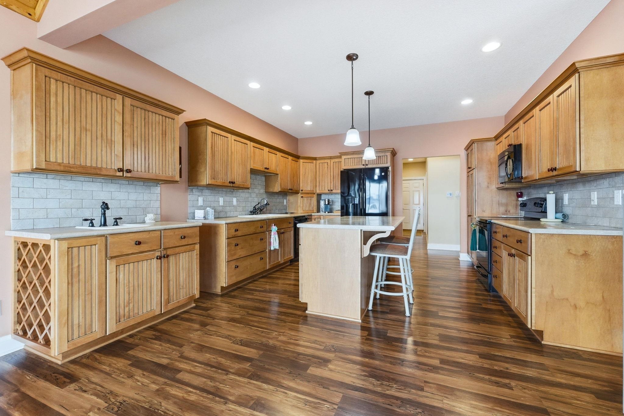 Kitchen with a breakfast bar, black appliances, and light countertops