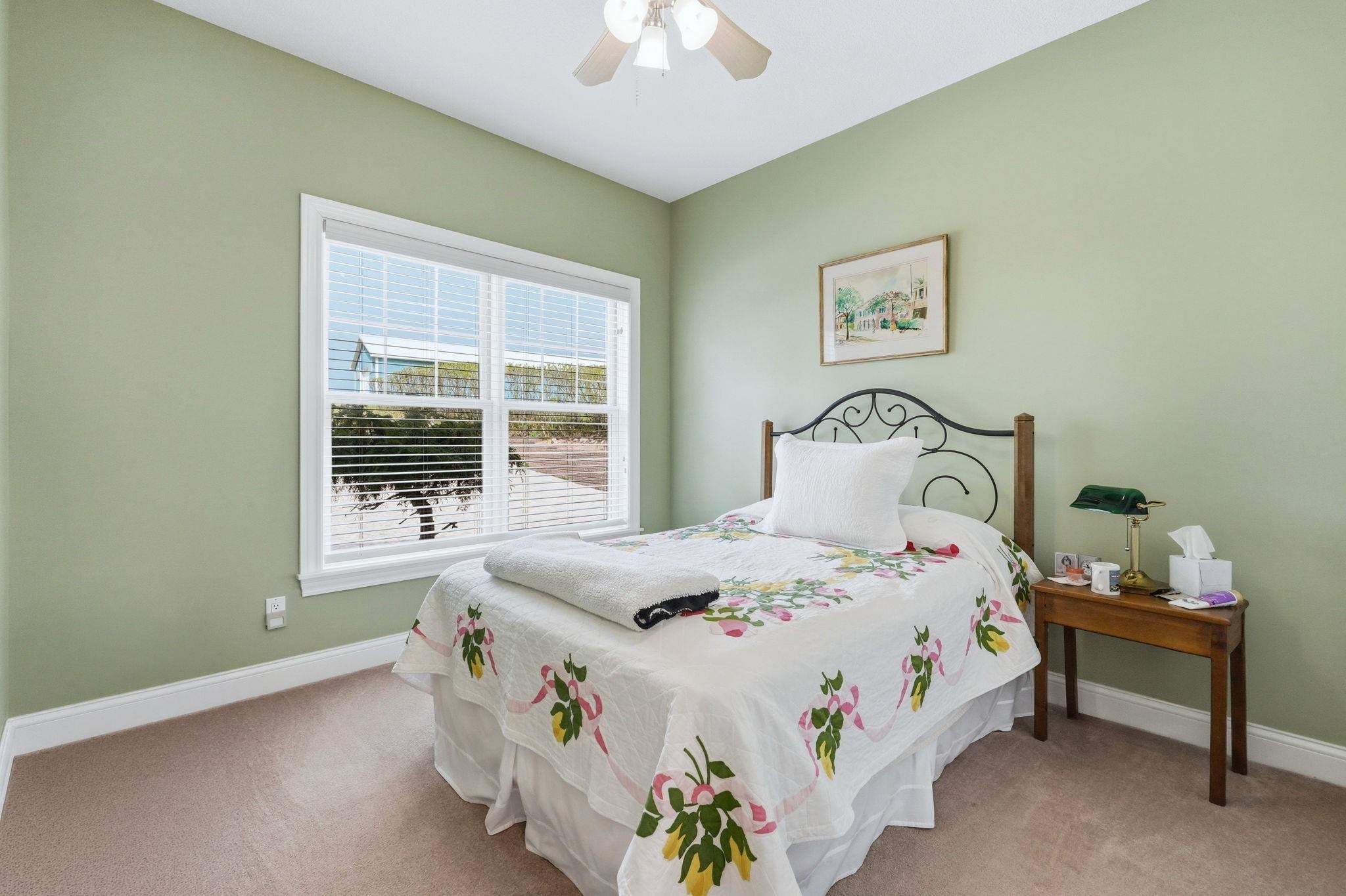 Bedroom with light colored carpet and ceiling fan