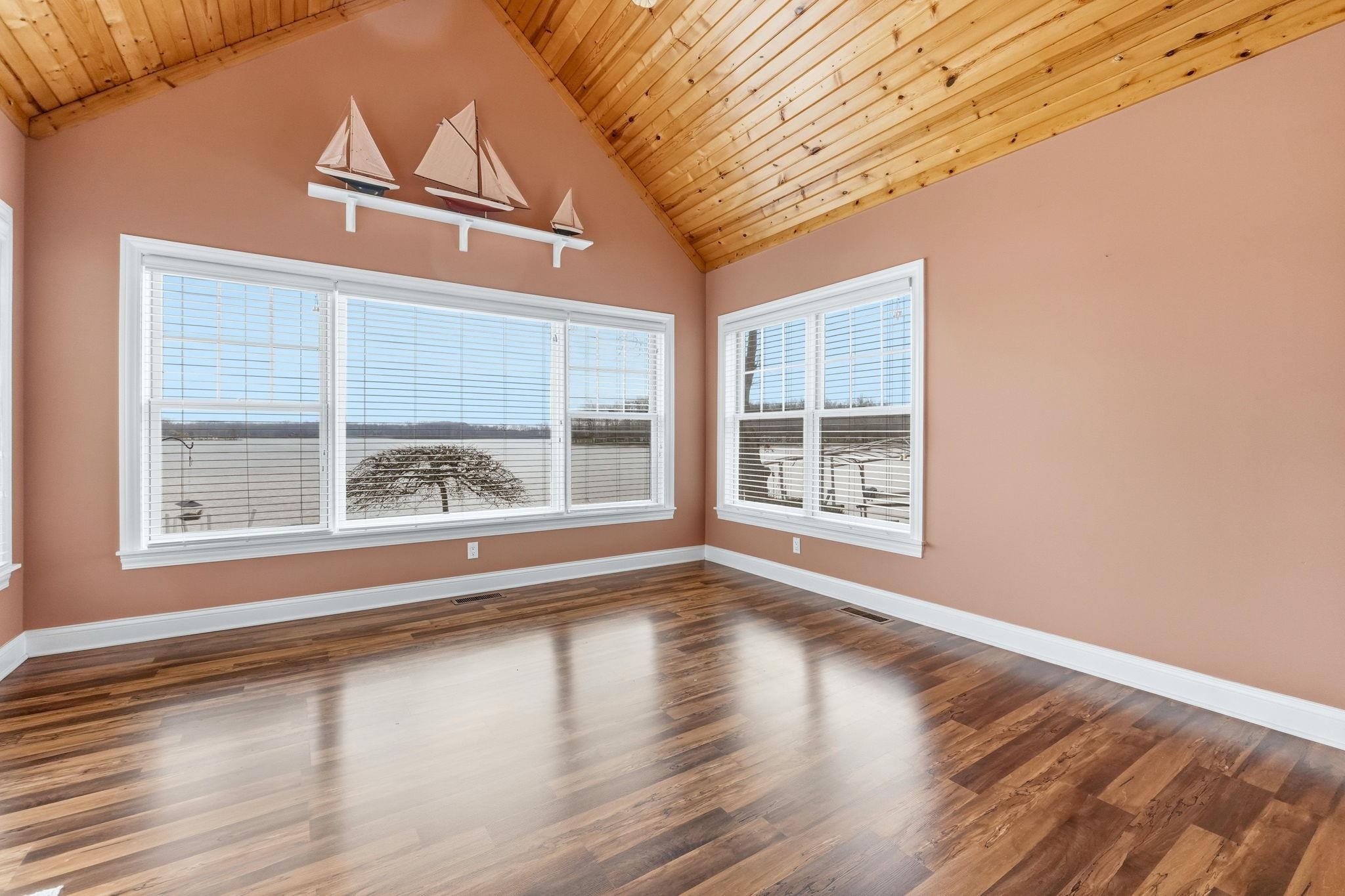 Spare room featuring a high wood ceiling and dark wood-type flooring