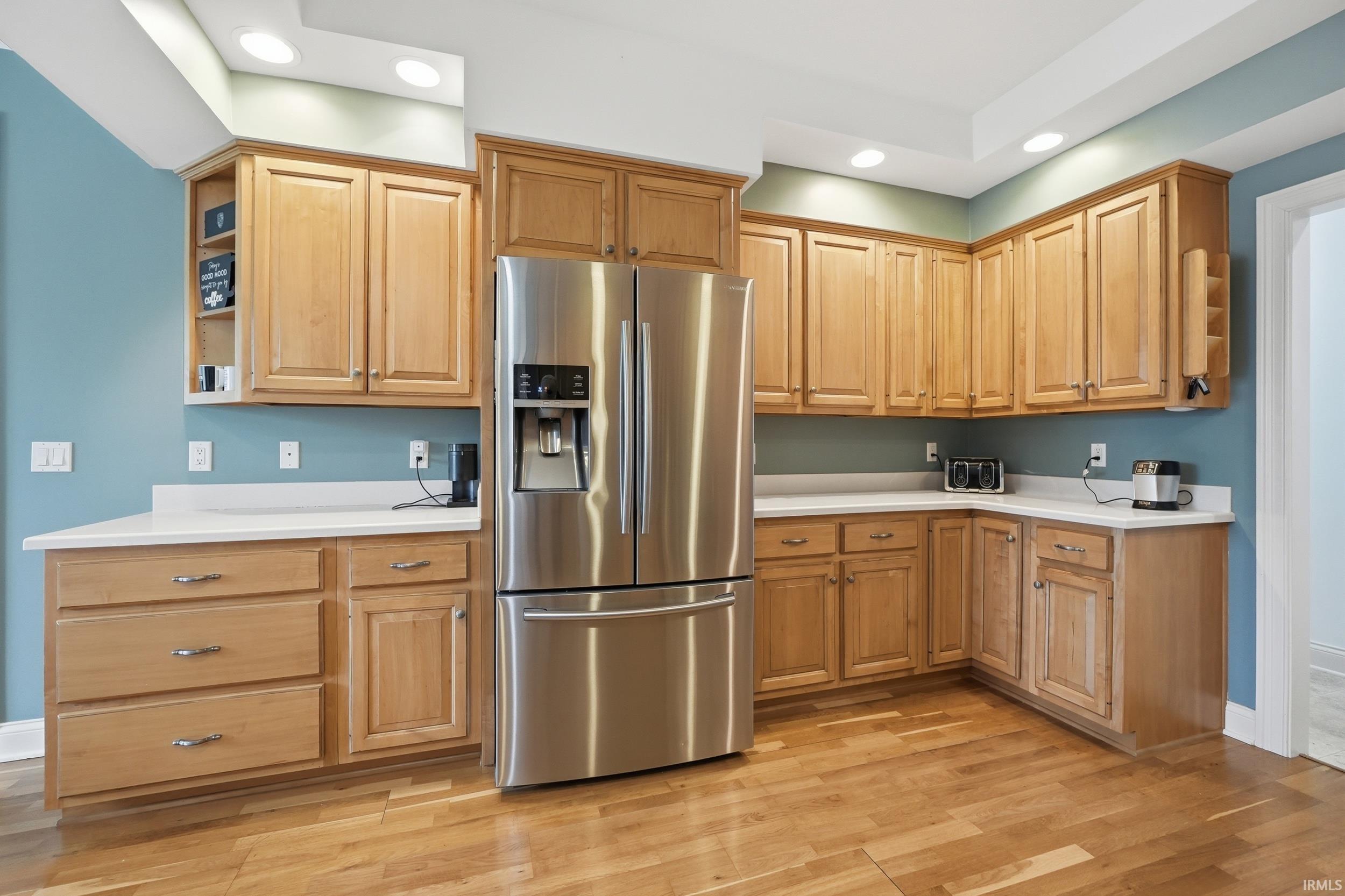 Kitchen featuring stainless steel refrigerator with ice dispenser, light countertops, light wood-style flooring, recessed lighting, and open shelves