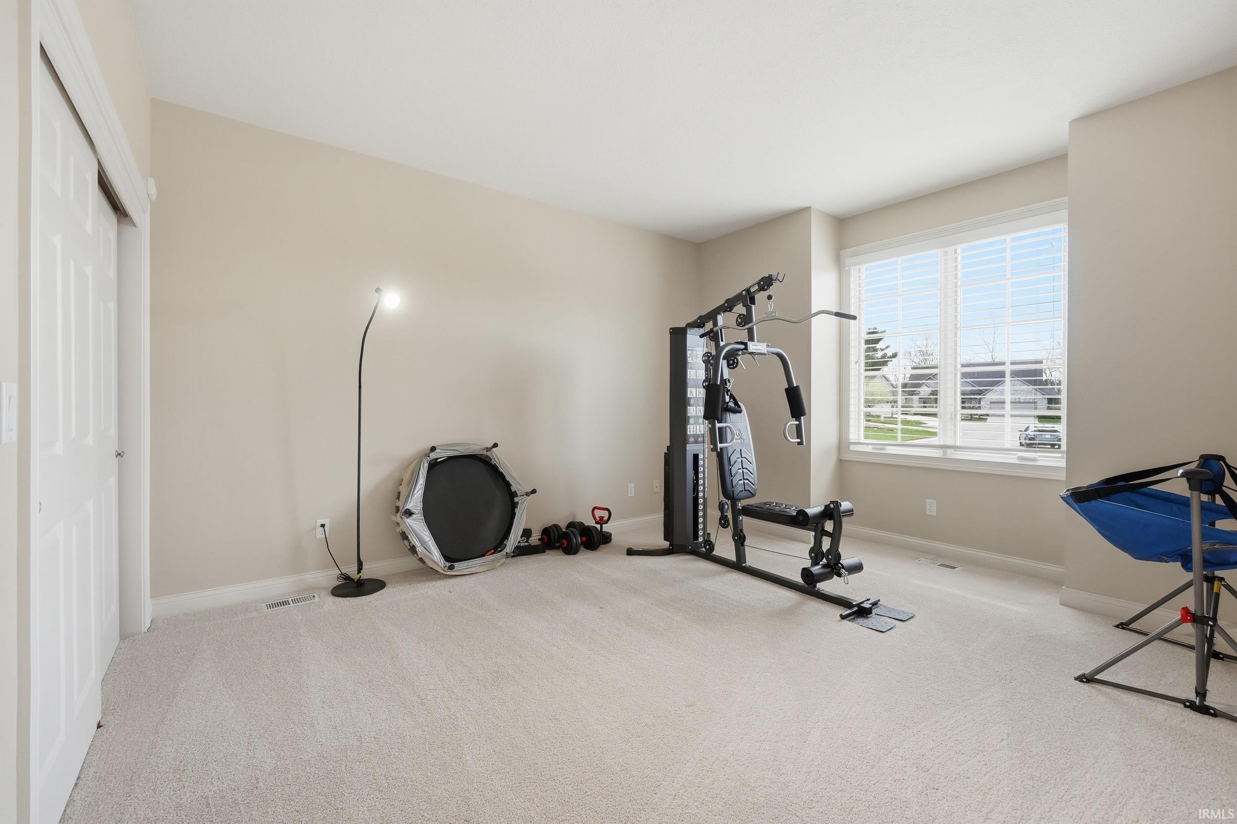 Workout room featuring light colored carpet and baseboards
