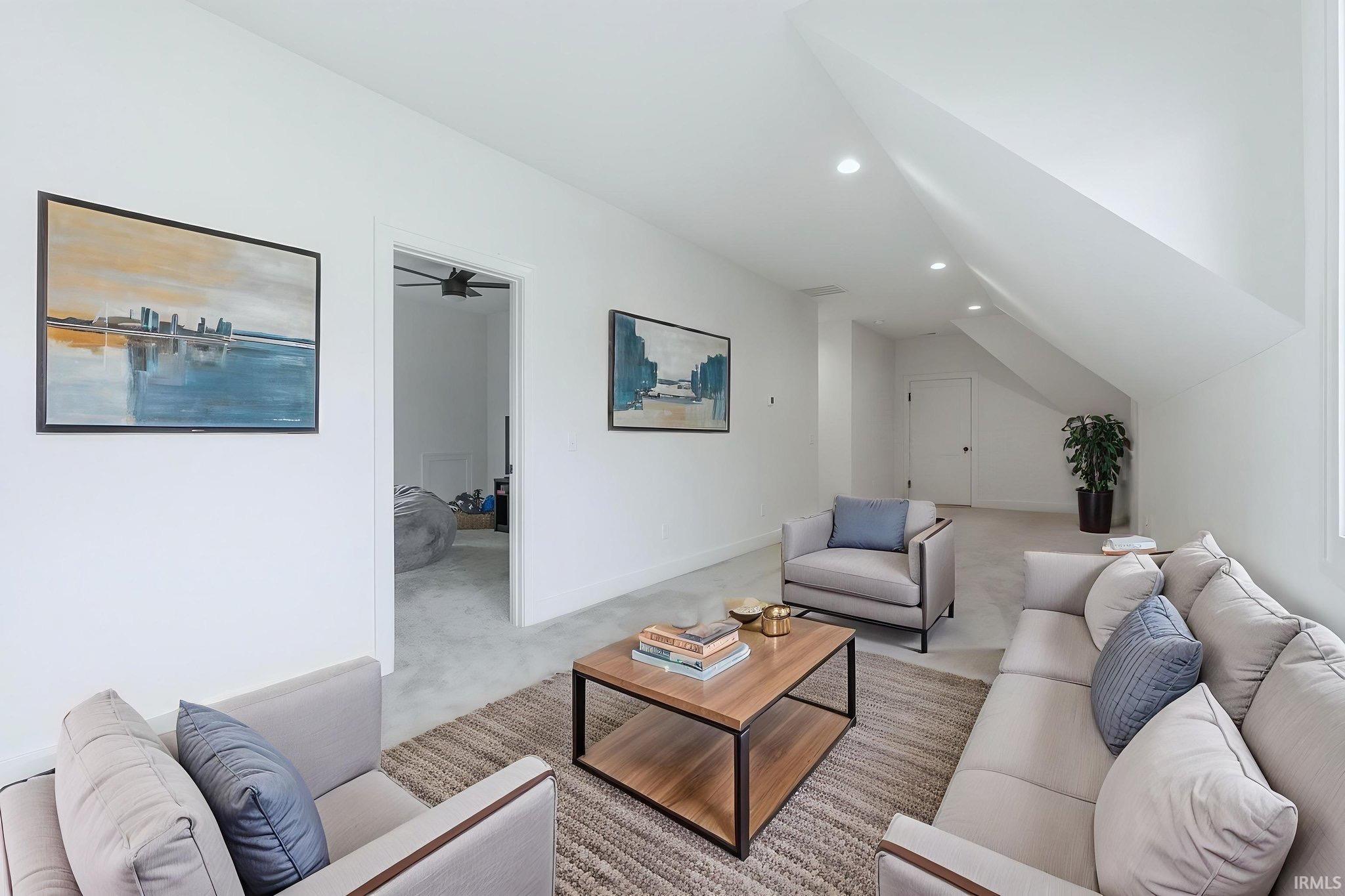 Living area with recessed lighting, light carpet, and vaulted ceiling