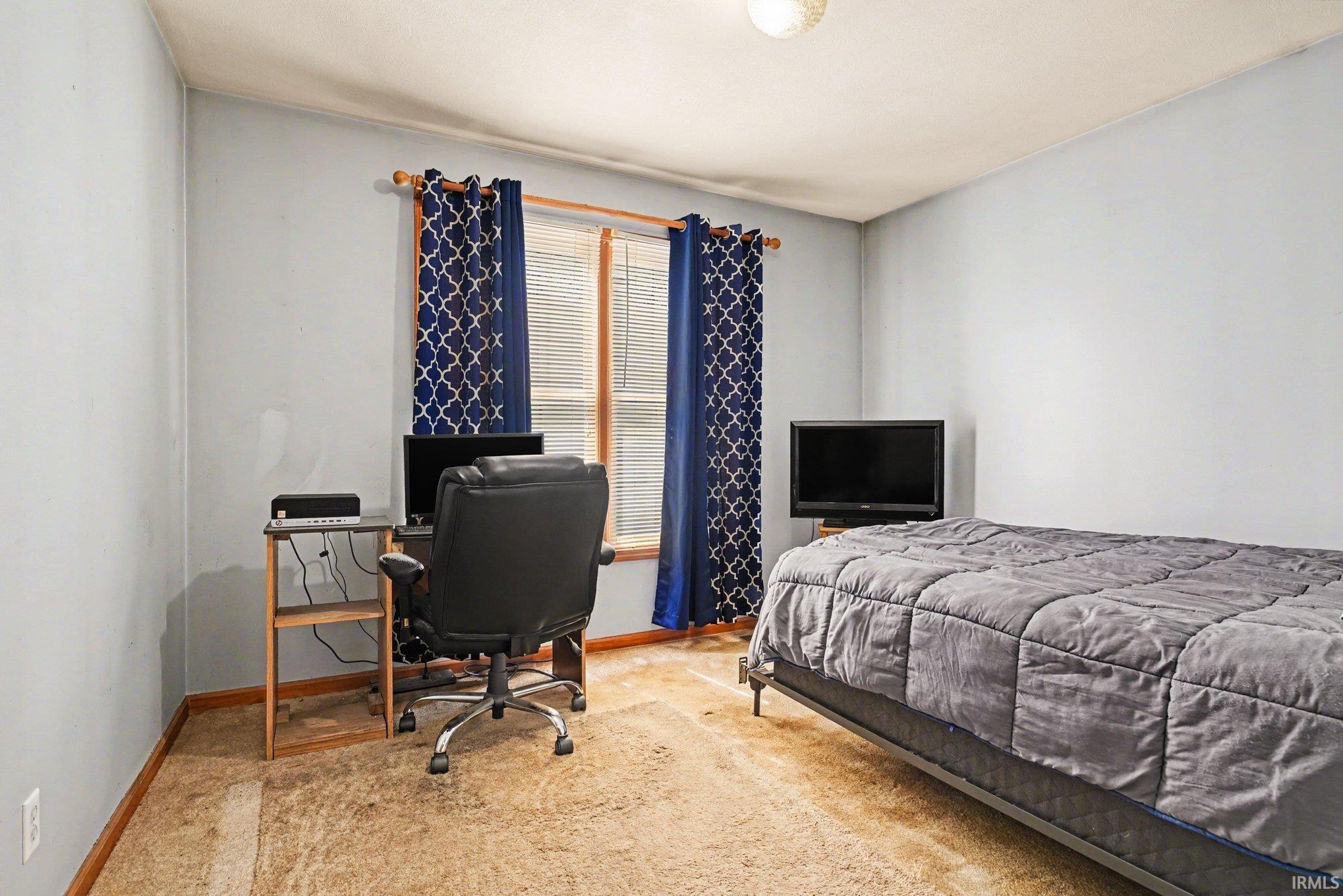 Bedroom featuring a desk and carpet