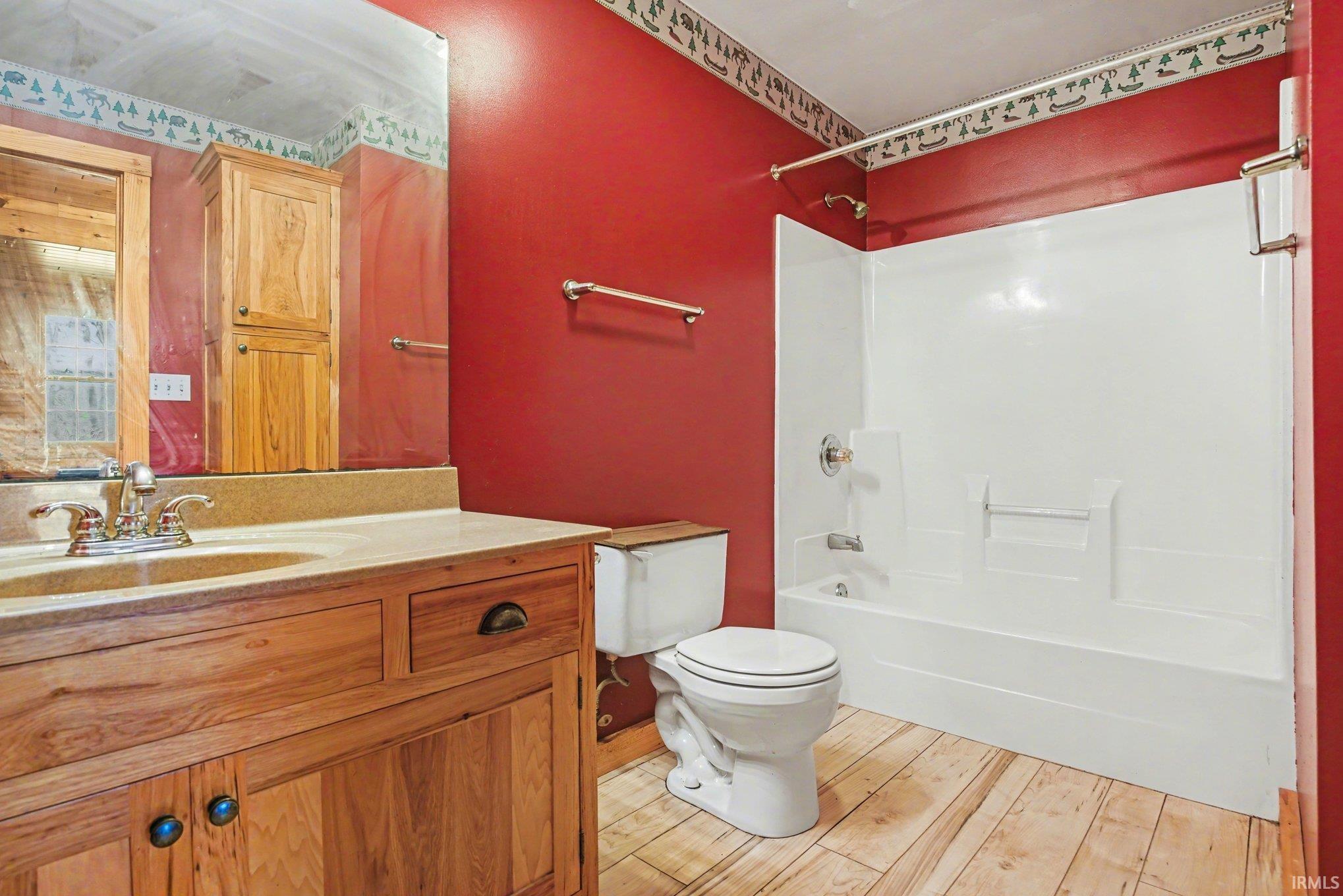 Full bathroom with vanity, tub / shower combination, and light wood-style floors