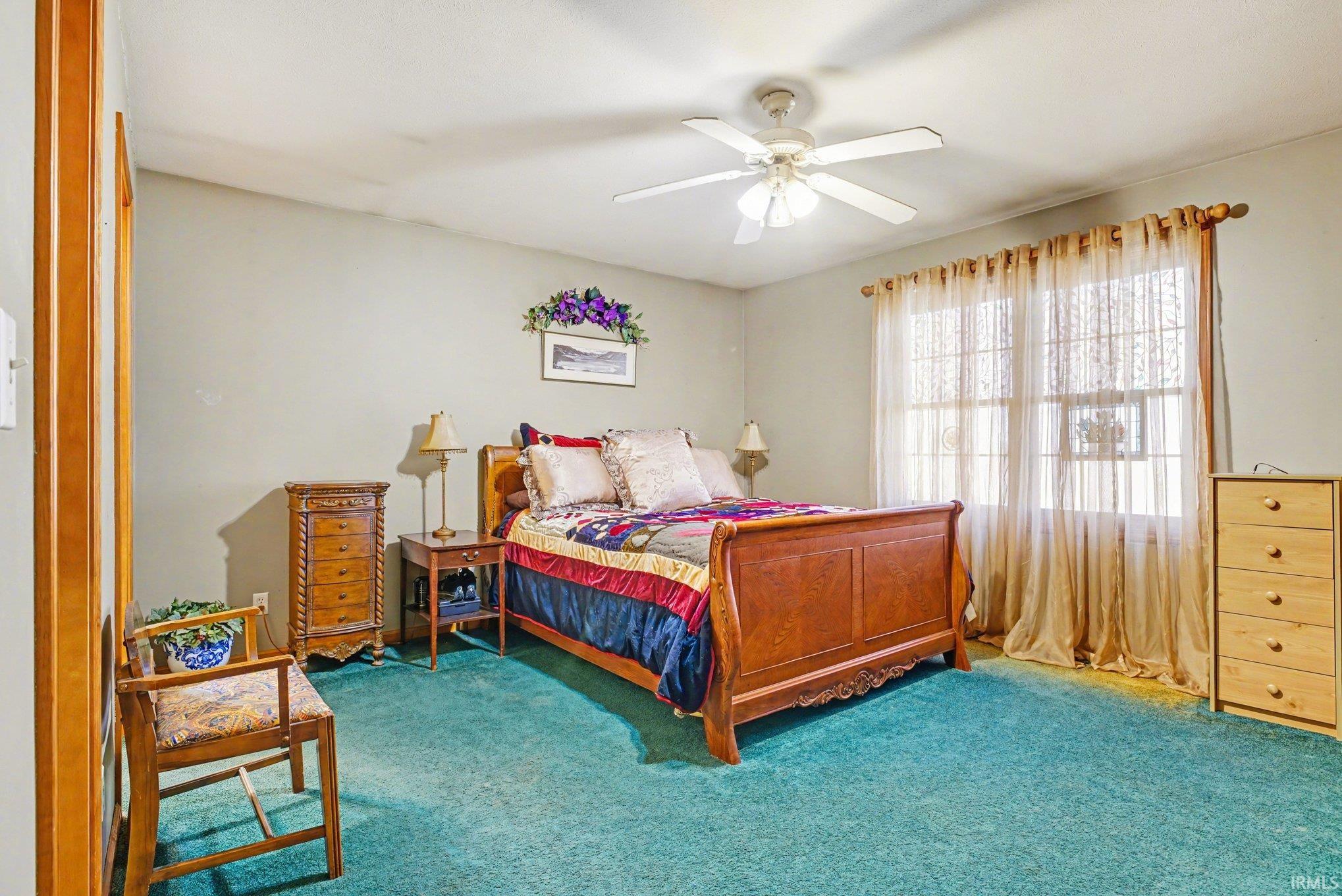 Carpeted bedroom with ceiling fan