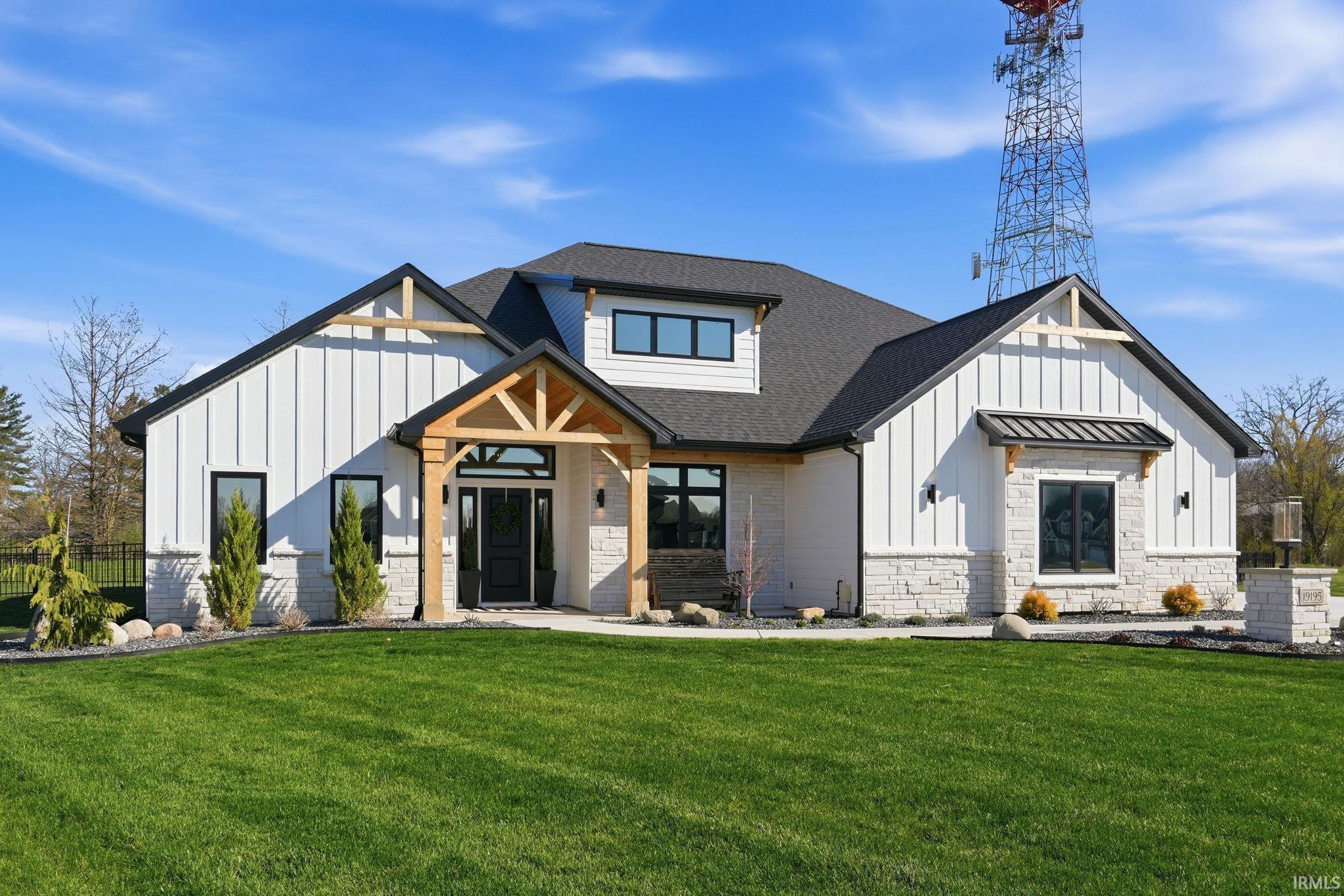 View of front of home featuring board and batten siding, a shingled roof, and stone siding