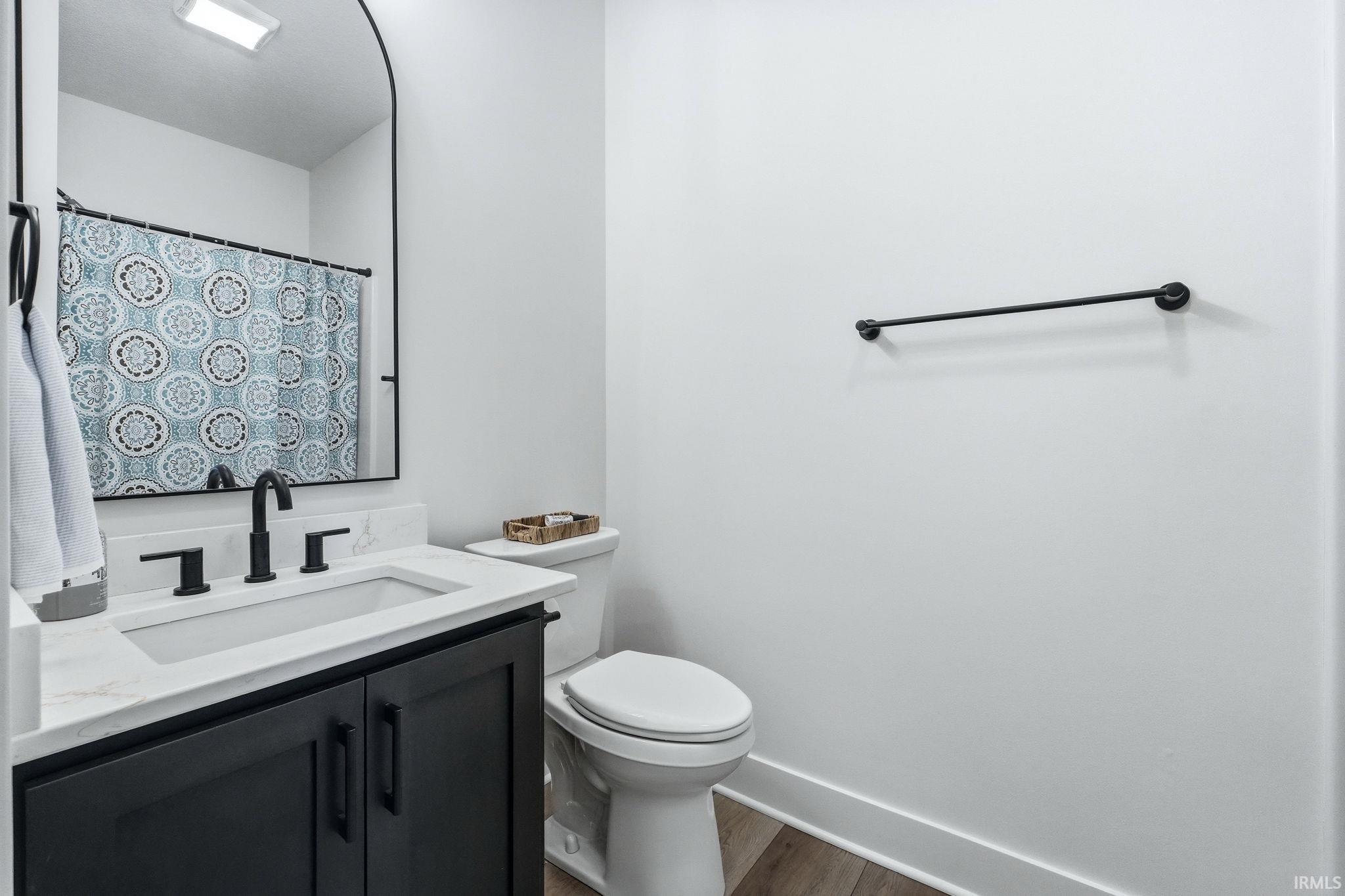 Bathroom featuring vanity, a shower with curtain, and dark wood-style floors