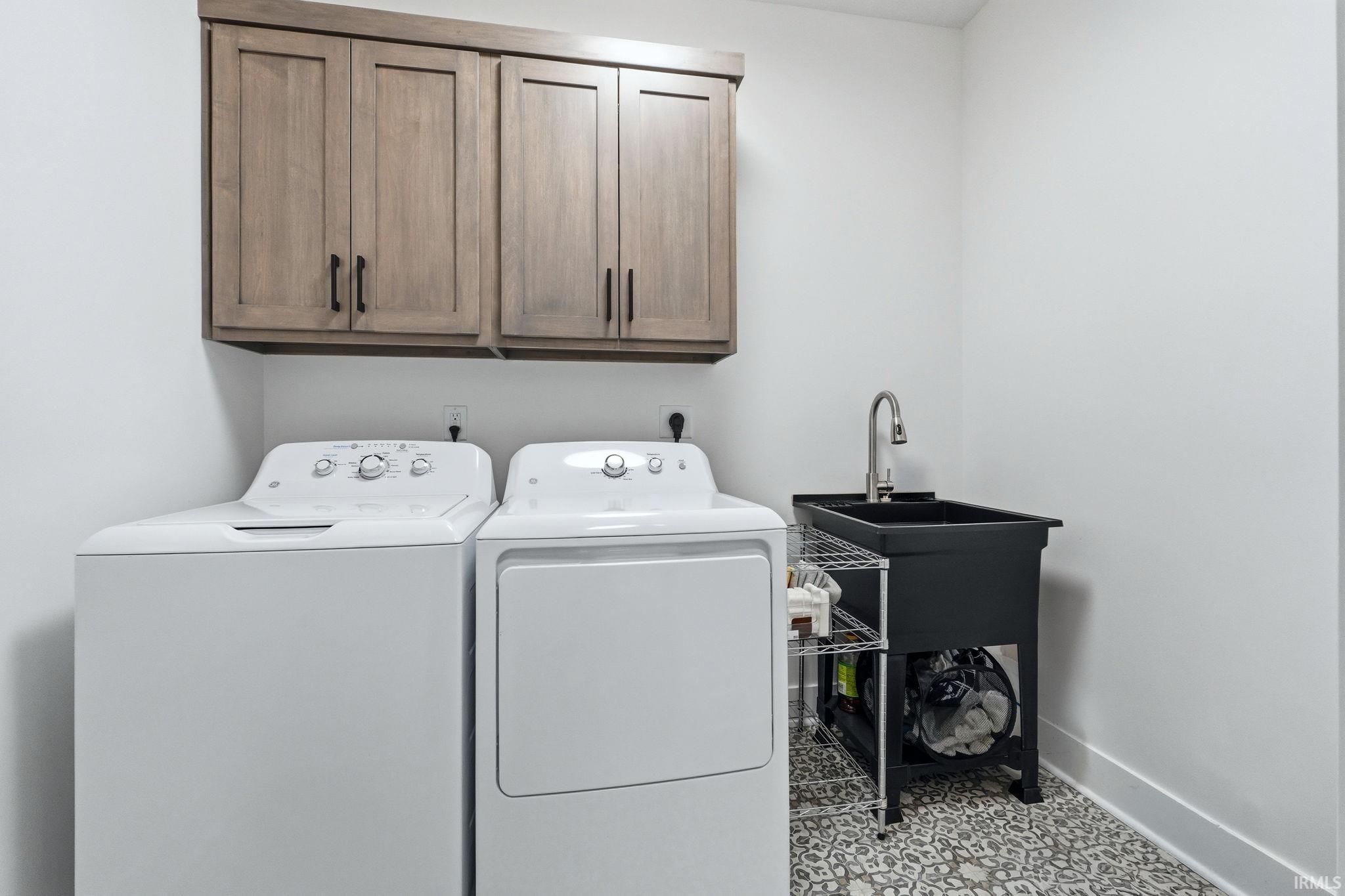 Laundry area with cabinet space and washing machine and clothes dryer