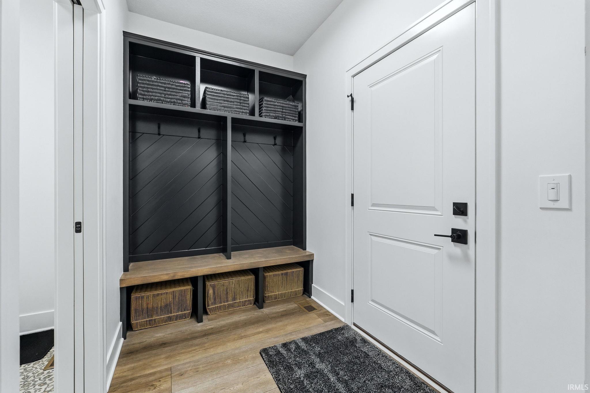 Mudroom with light wood-style flooring and baseboards