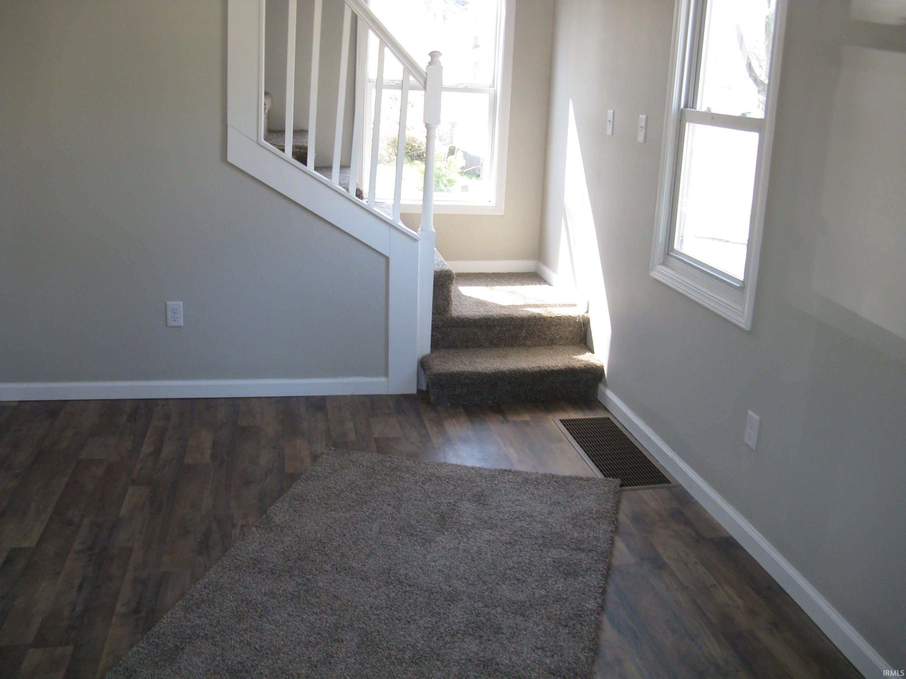 Stairway featuring baseboards and wood finished floors
