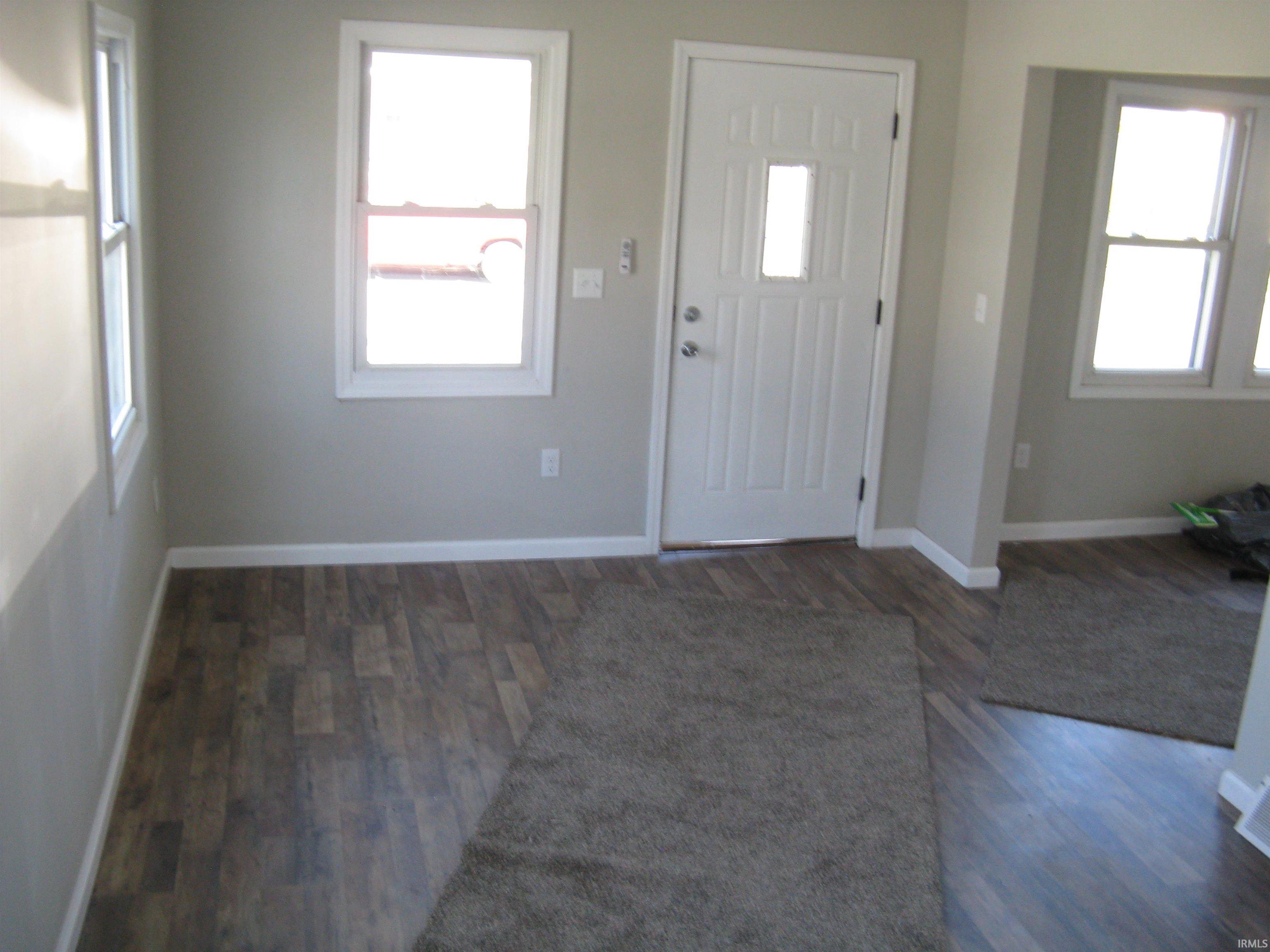 Foyer entrance with healthy amount of natural light and dark wood finished floors
