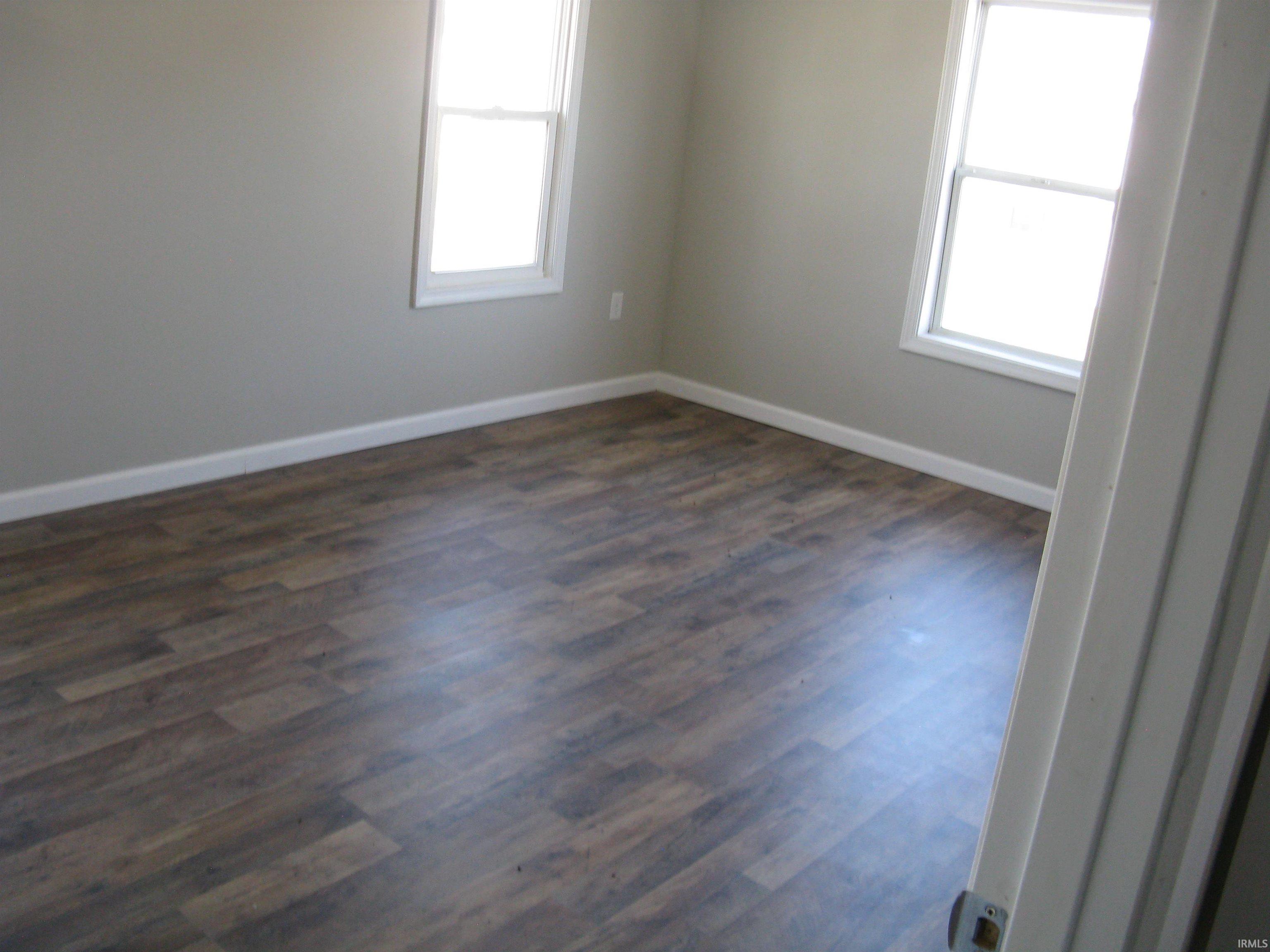 Unfurnished room featuring dark wood-type flooring