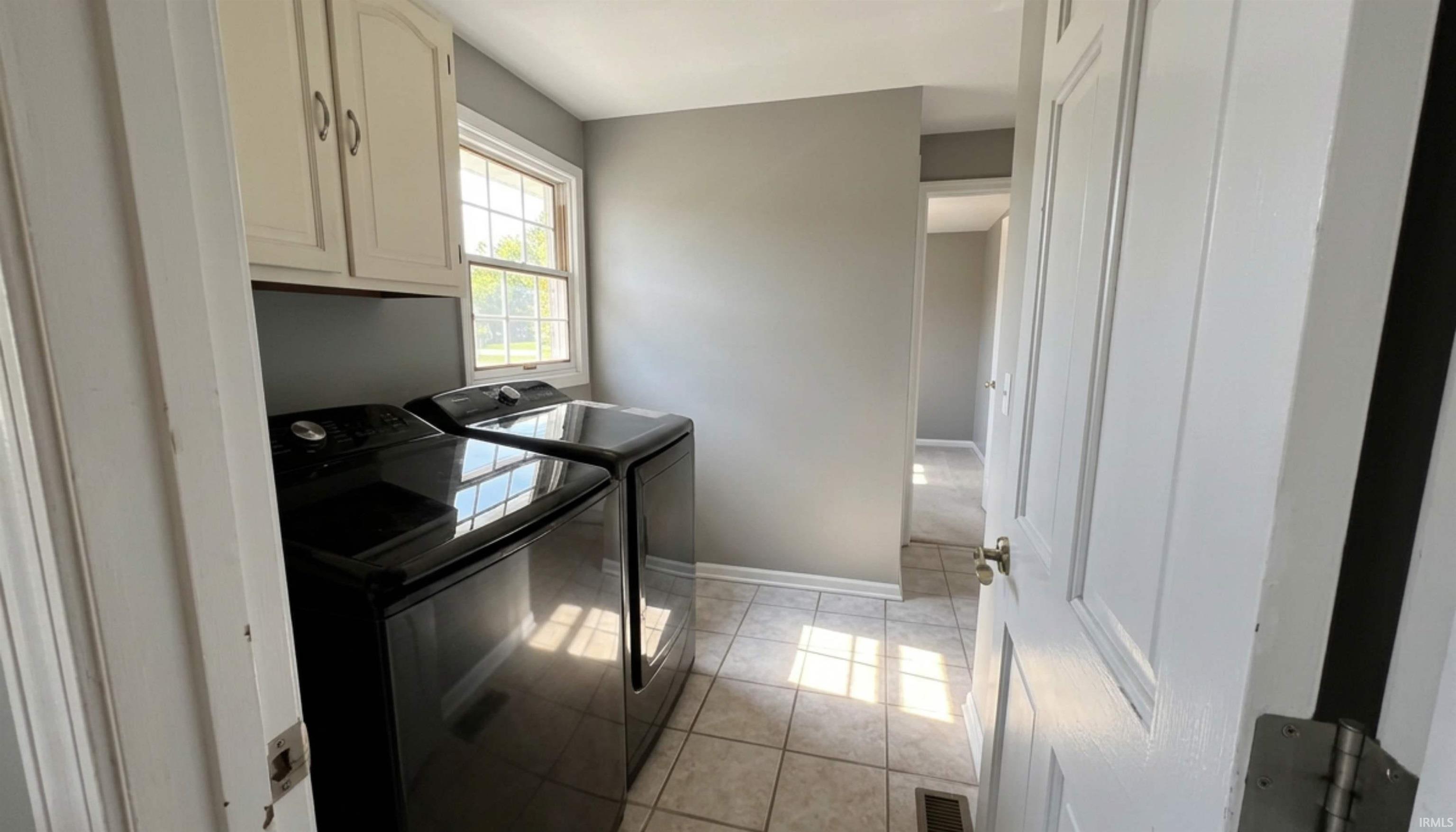 Laundry room featuring ceramic tile floors, and cabinet space. Entry Bedroom 5 as well as the 2-car garage with pull down attic entry. (Washer/Dryer NOT included)