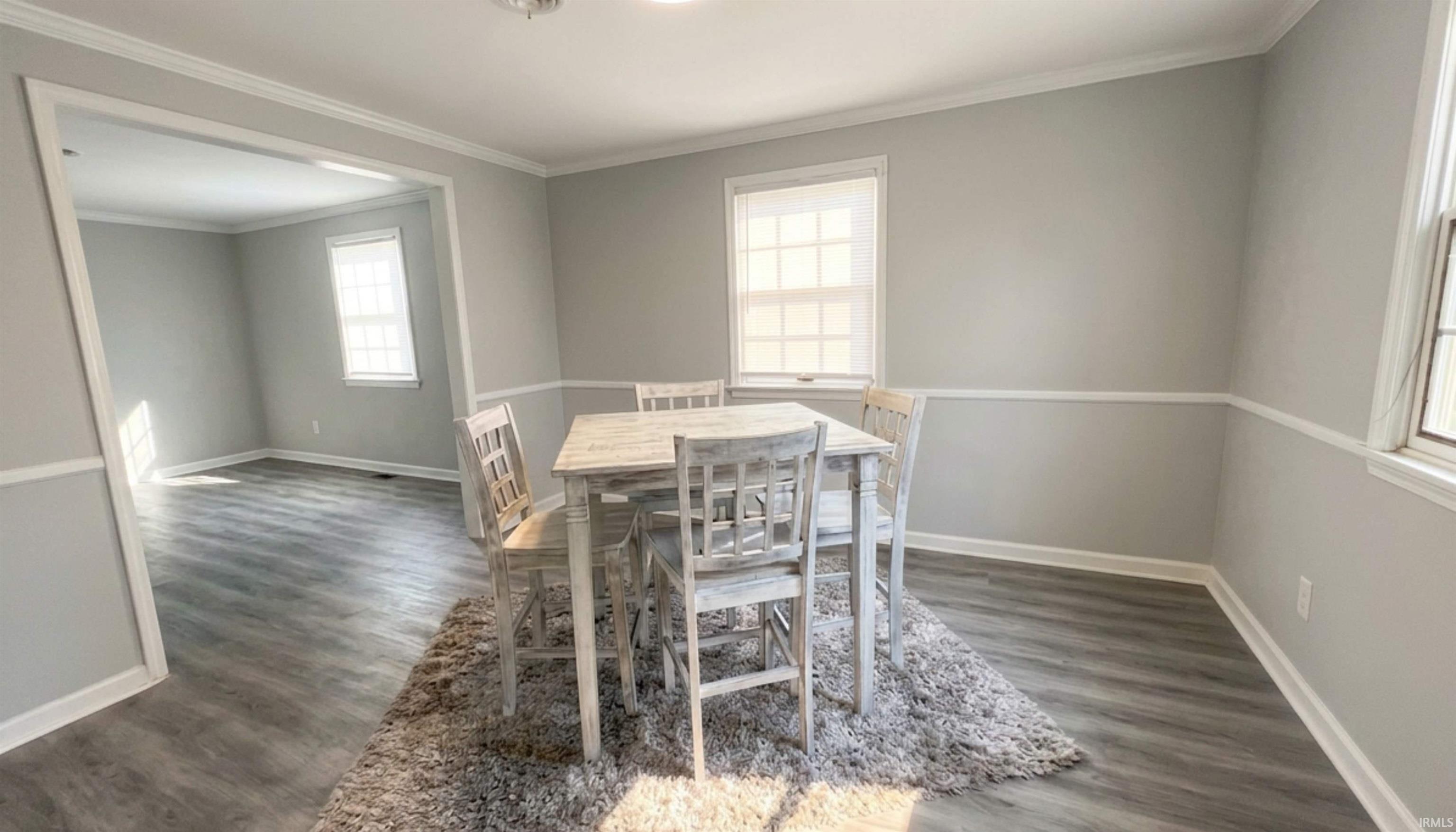 Dining space featuring wood floors and chair molding. (AI Generated staging)