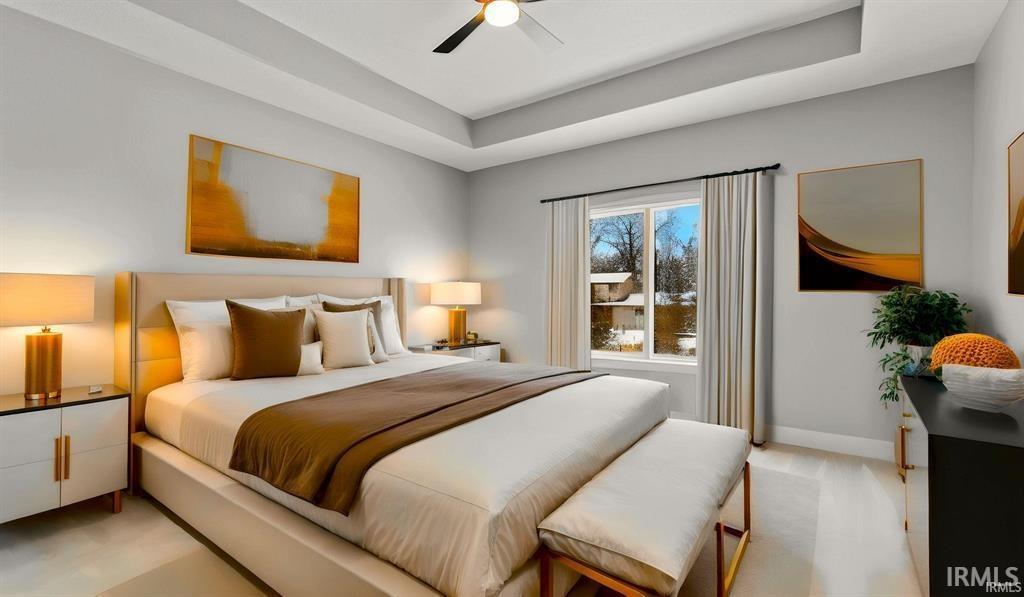 Bedroom featuring a tray ceiling and a ceiling fan