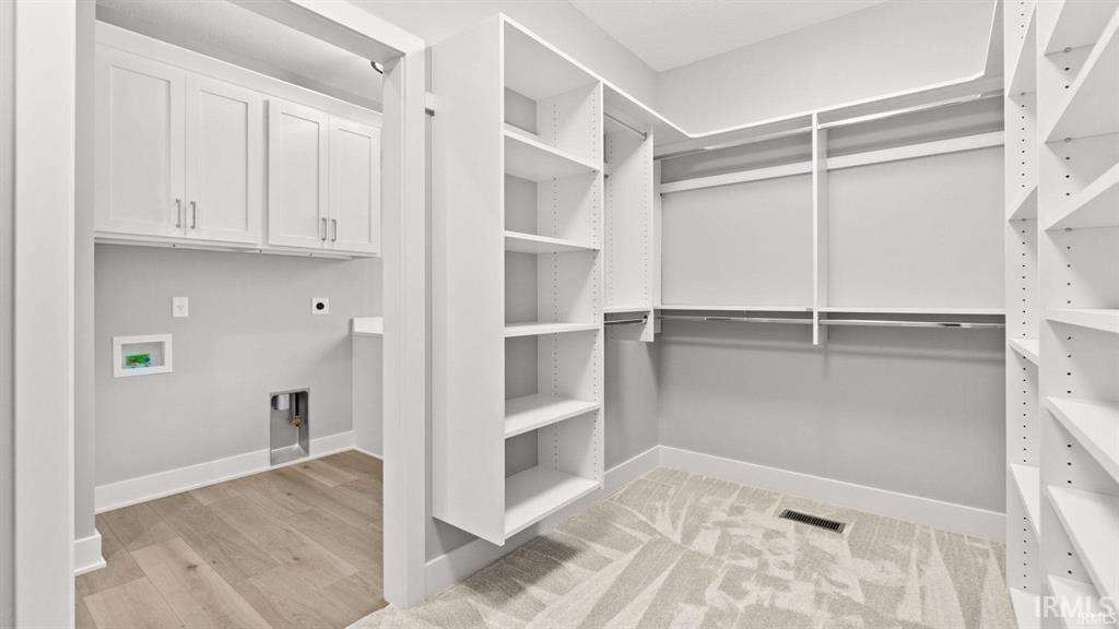 Walk in closet featuring light wood-style floors
