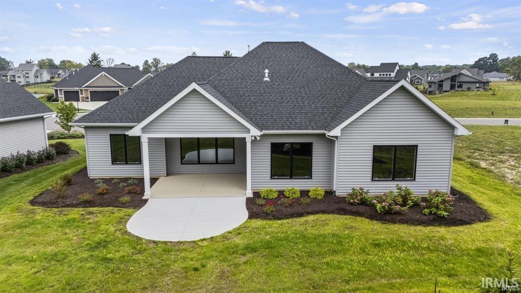View of front facade featuring a front yard, a residential view, and a shingled roof