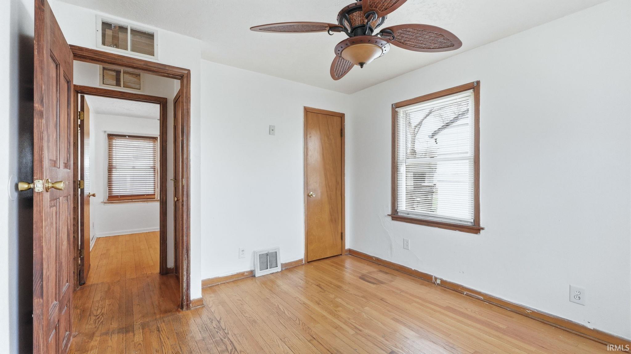 Unfurnished bedroom with light wood-style floors and a ceiling fan