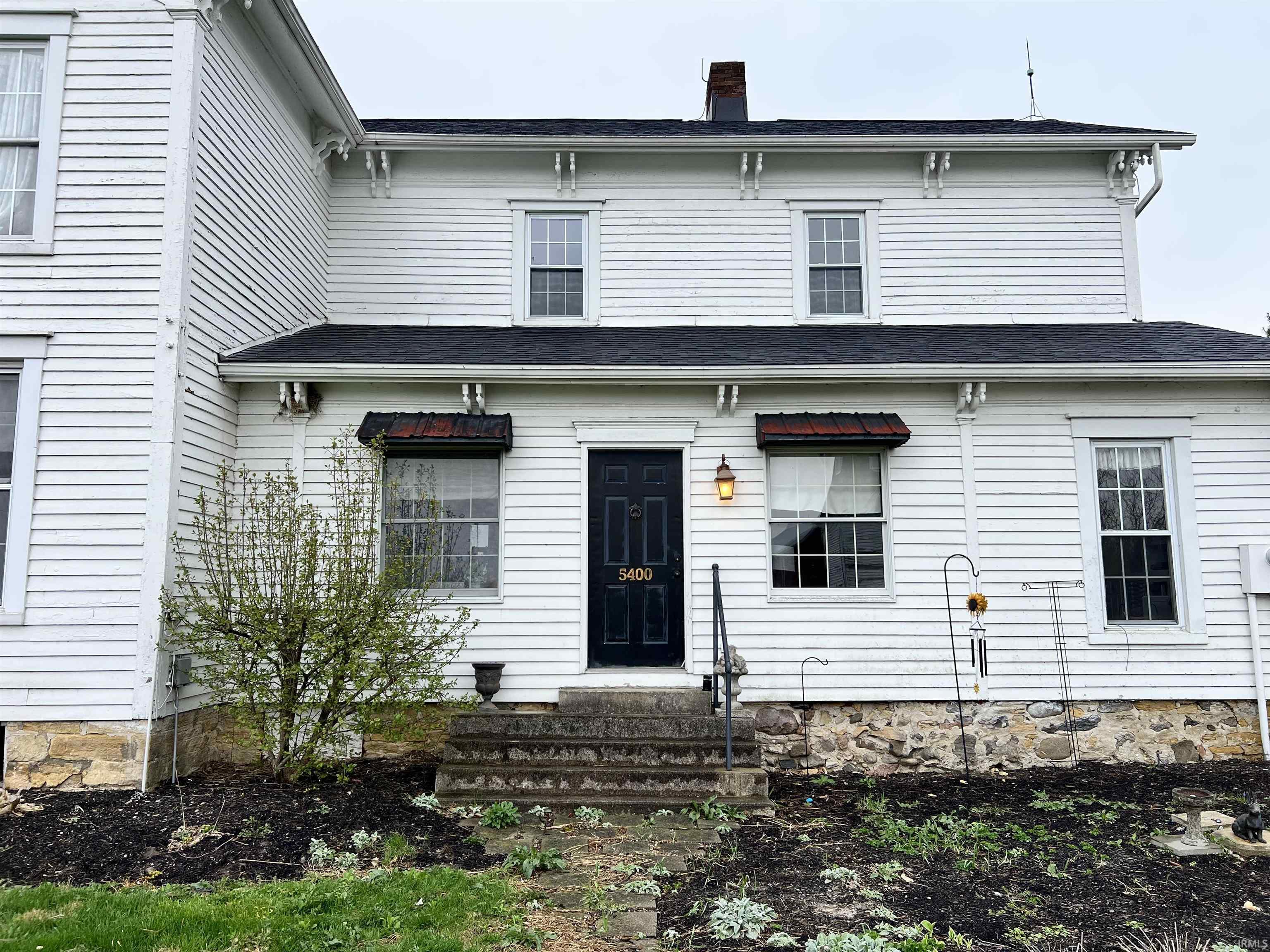 View of front of property with a chimney and entry steps