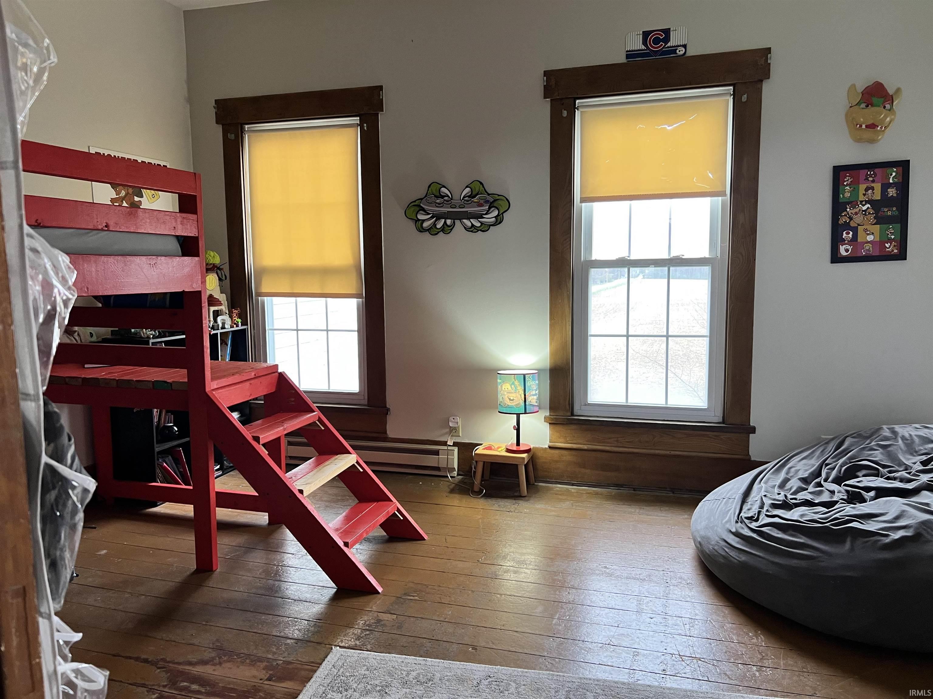 Bedroom featuring dark wood finished floors and multiple windows