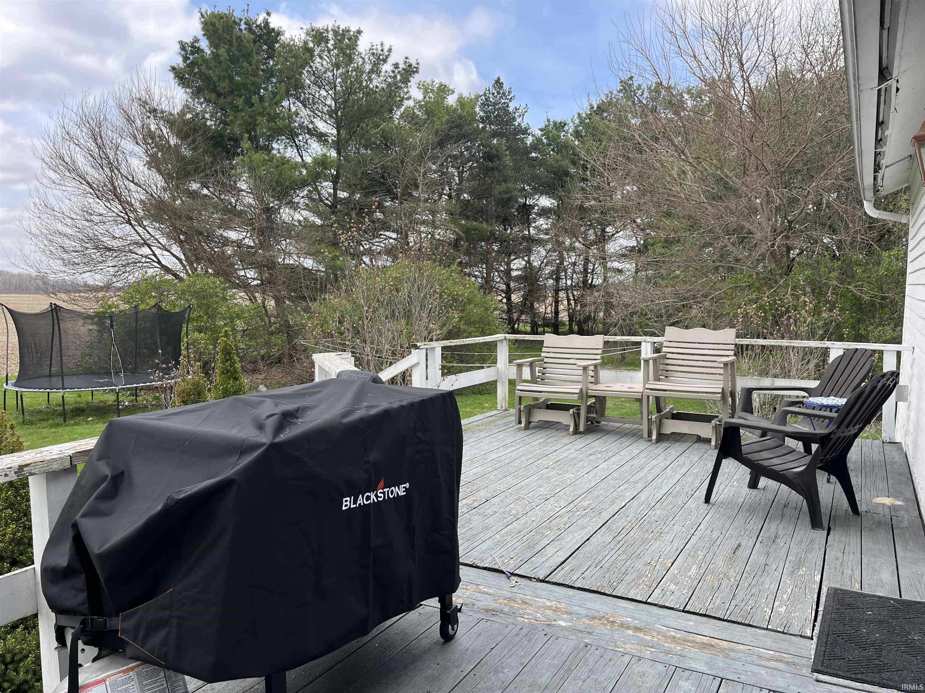 Wooden deck with a grill and a trampoline