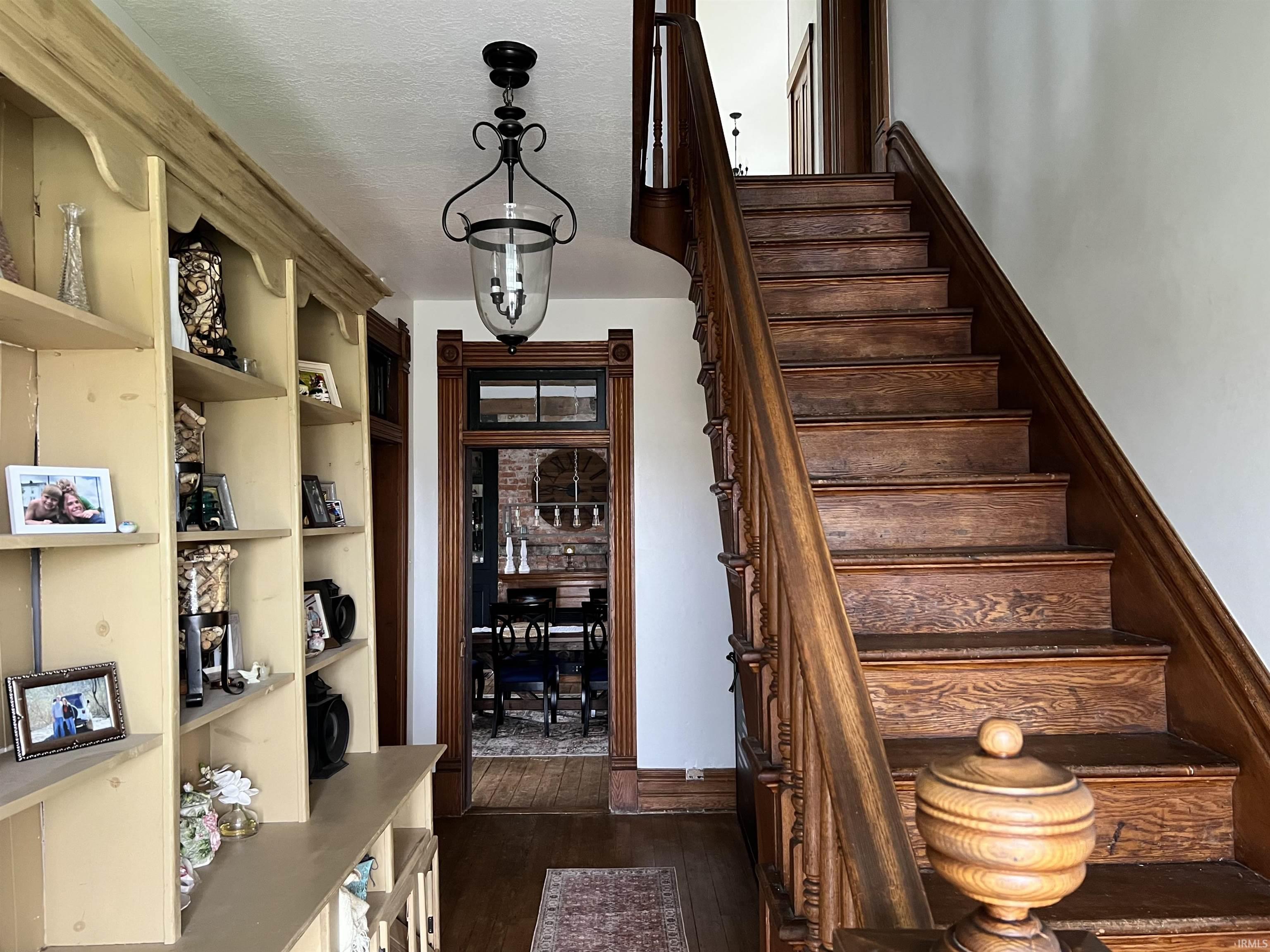 Staircase with wood finished floors and a textured ceiling