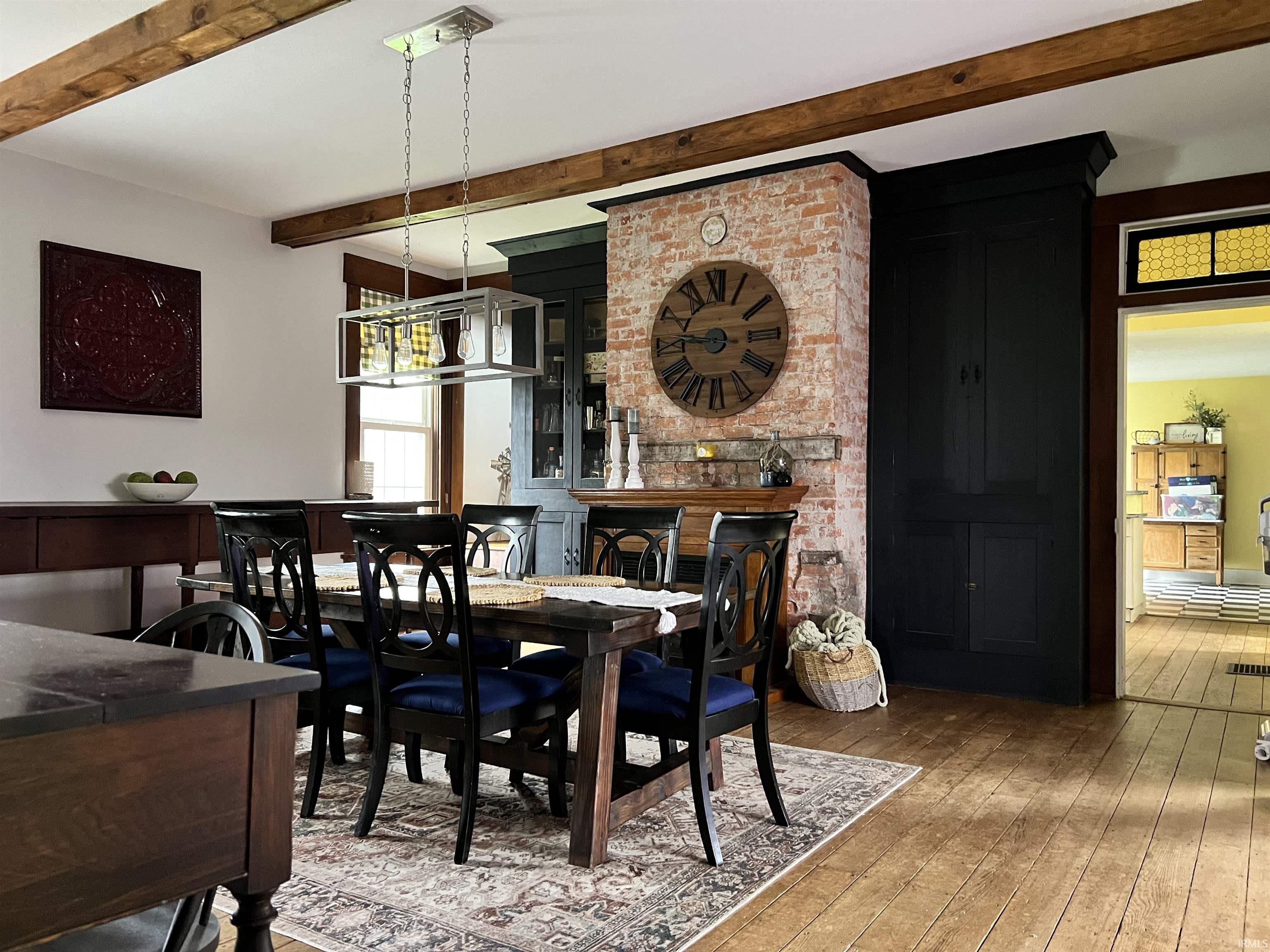 Dining area with light wood-style flooring and beamed ceiling
