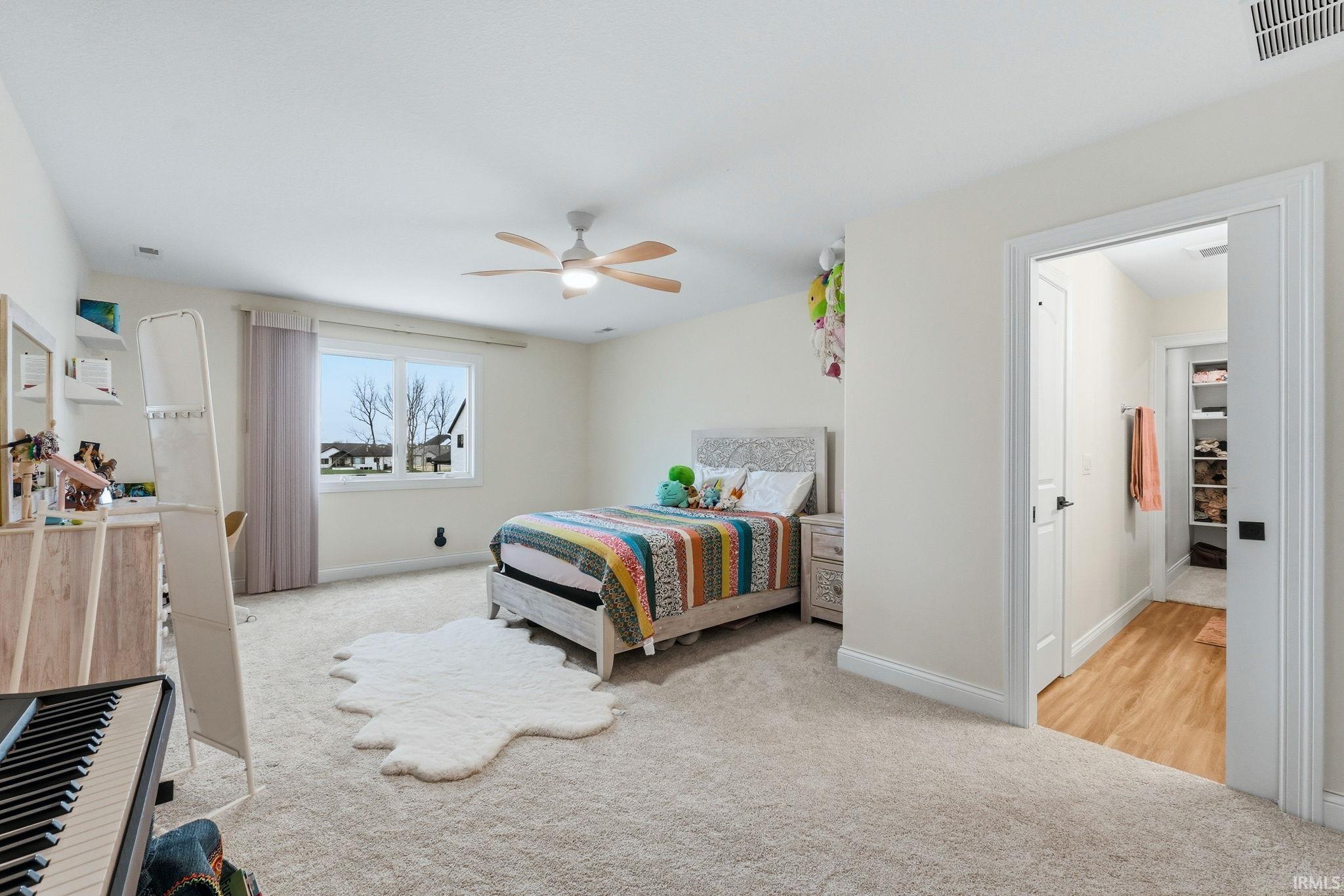 Bedroom featuring light colored carpet and ceiling fan