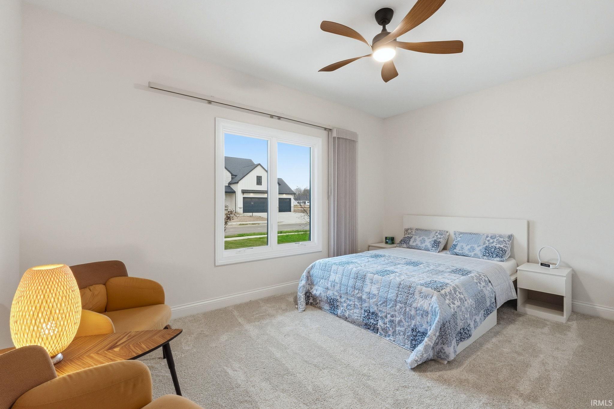 Bedroom with a ceiling fan and light colored carpet