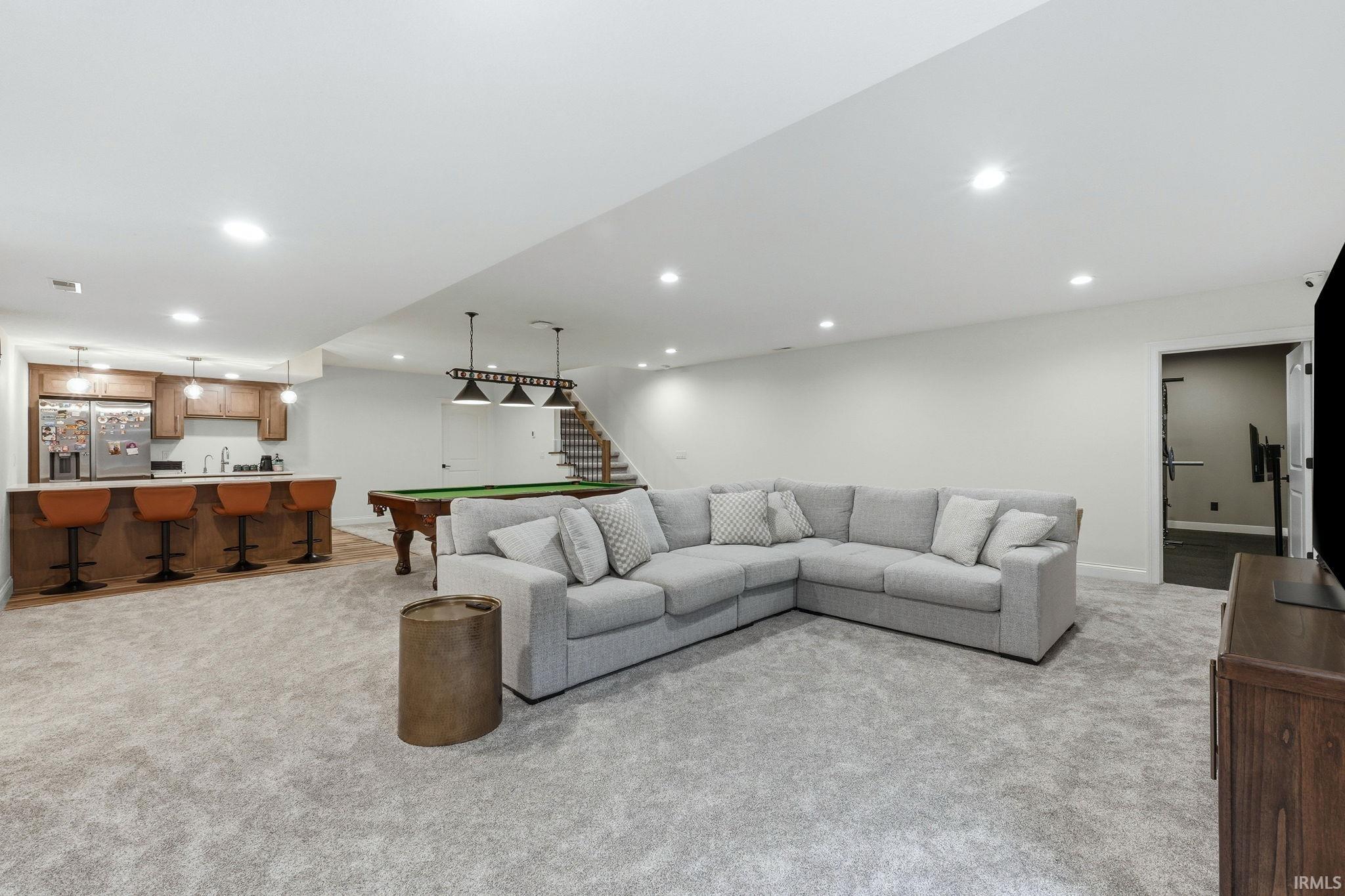 Living room featuring light carpet, wet bar, recessed lighting, and billiards table