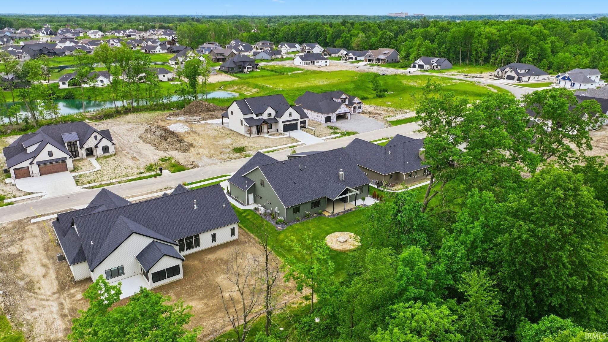 Expansive new construction community featuring diverse architectural styles, abundant green spaces, and a prominent water feature