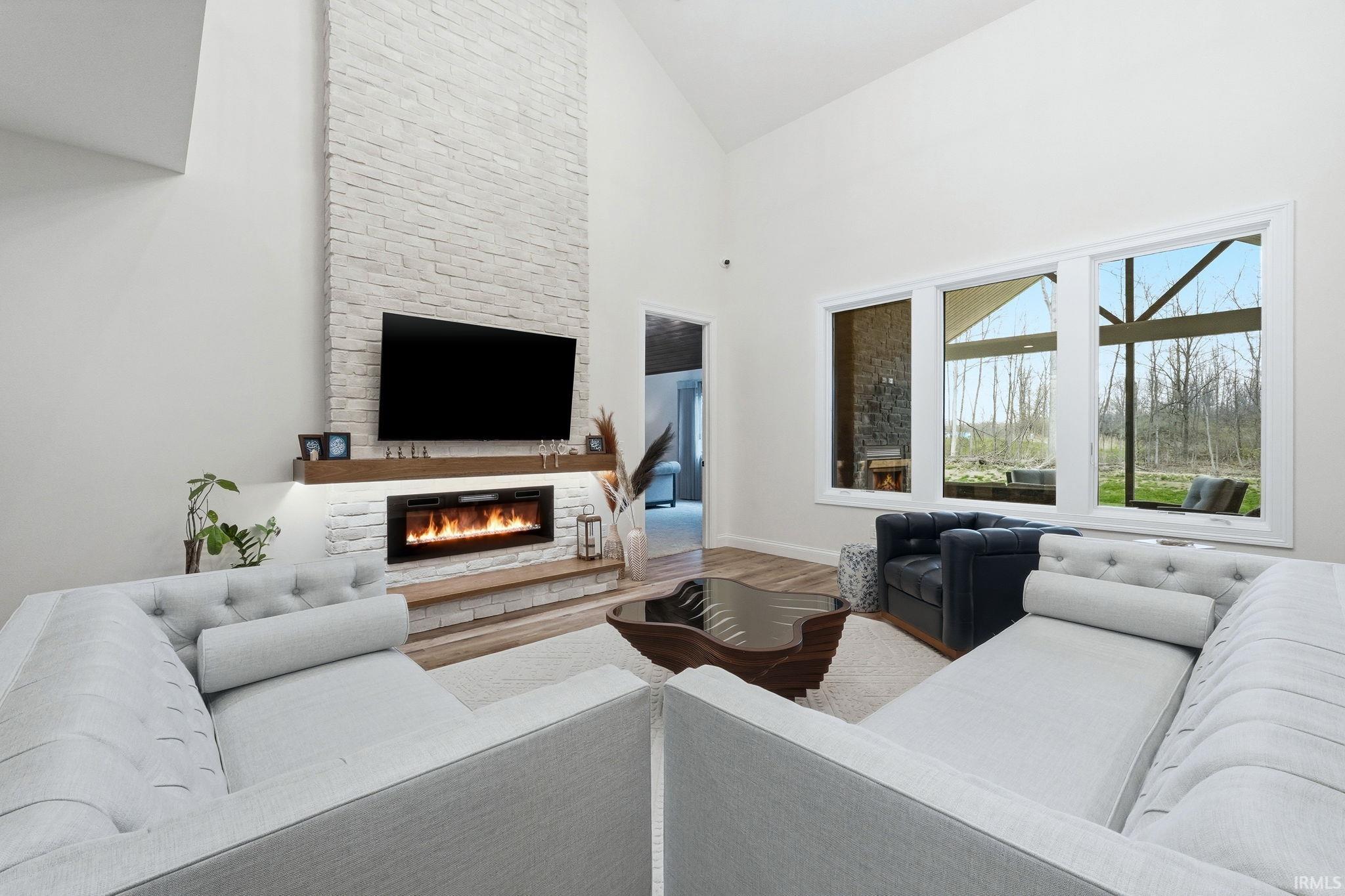 Living room featuring vaulted ceiling, wood finished floors, and a fireplace