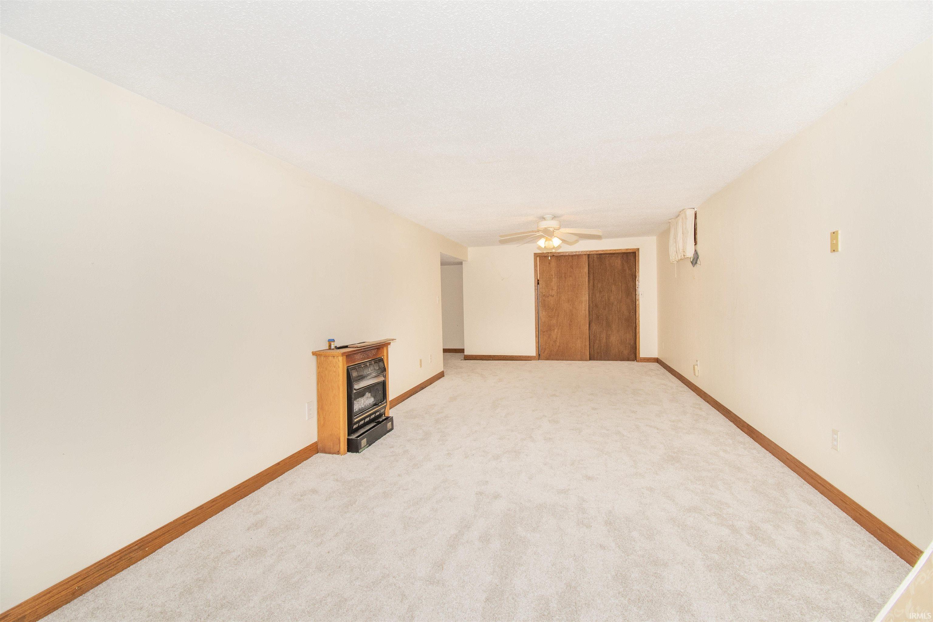 Unfurnished room featuring light carpet and ceiling fan