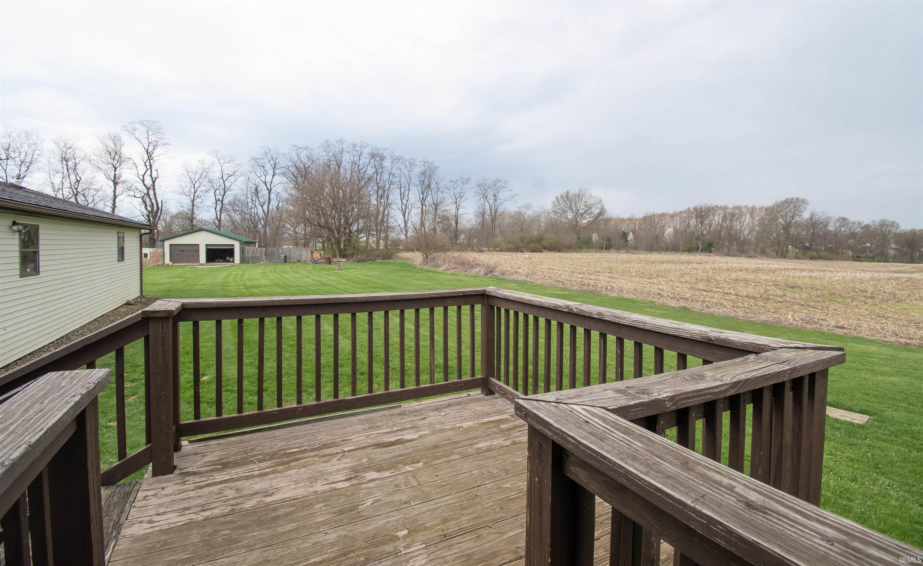 Wooden deck with a lawn and an outdoor structure
