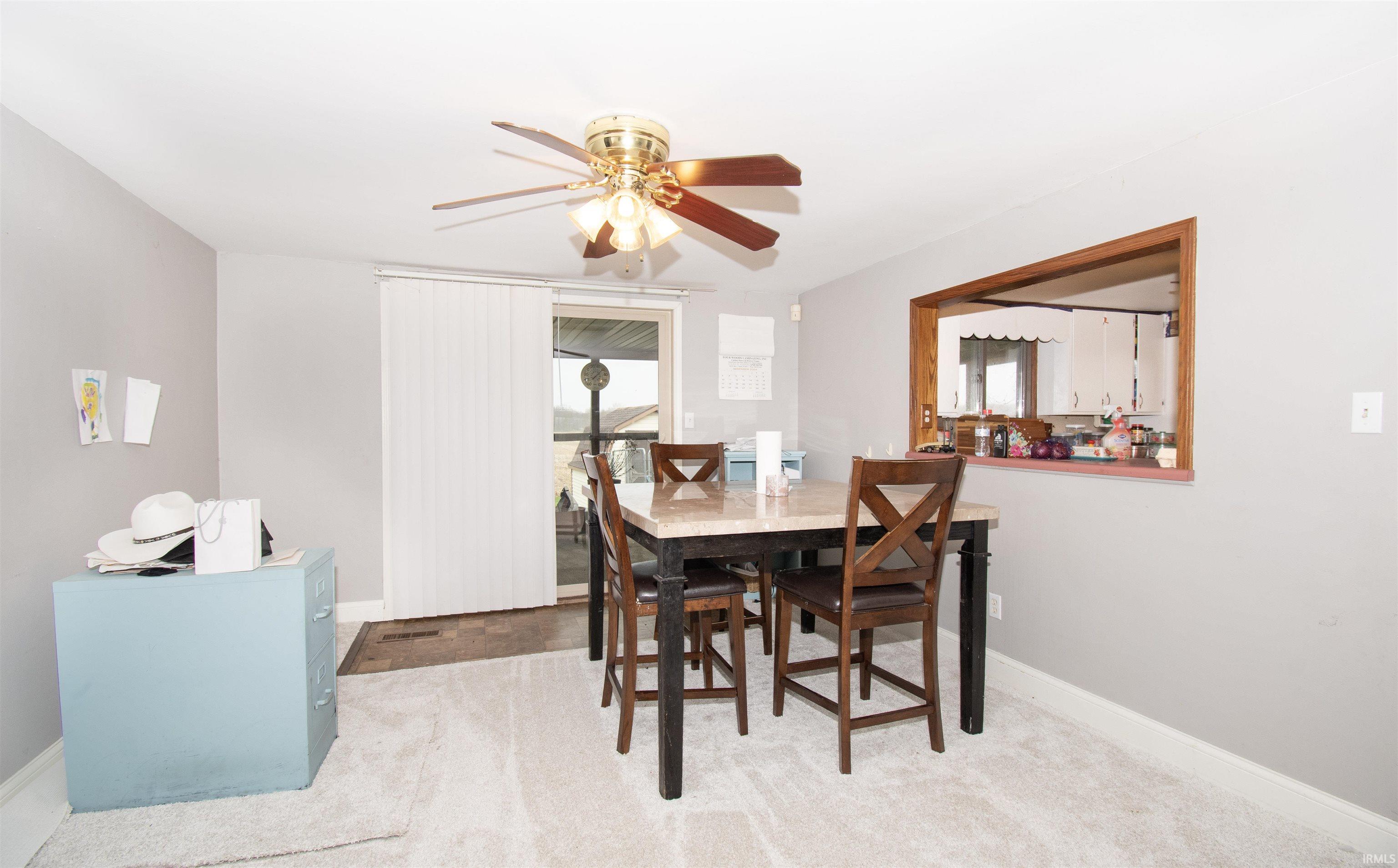 Carpeted dining area with baseboards and a ceiling fan