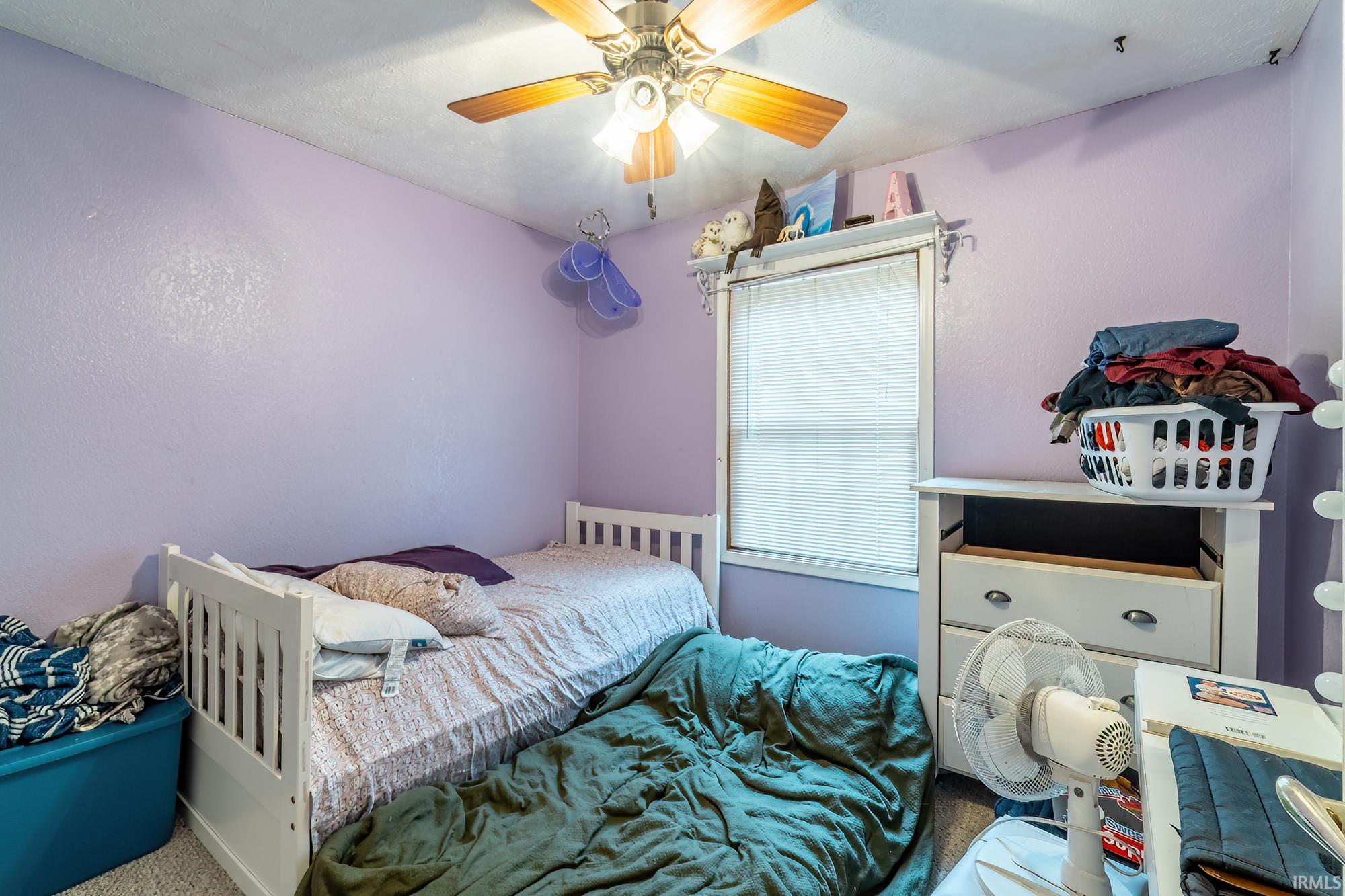 Bedroom featuring ceiling fan and carpet