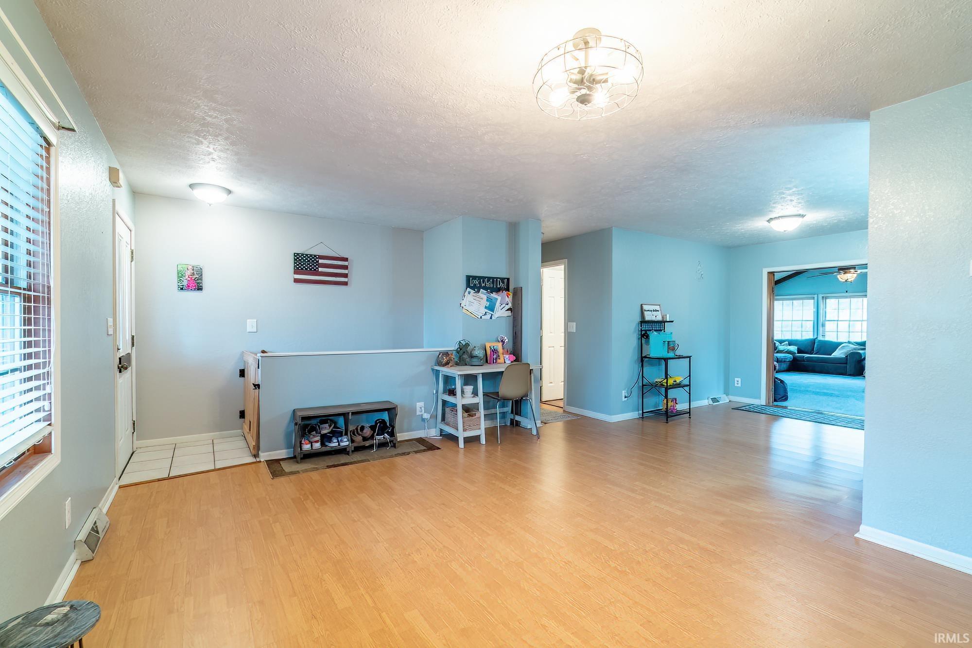 Living area with light wood-style flooring and a textured ceiling
