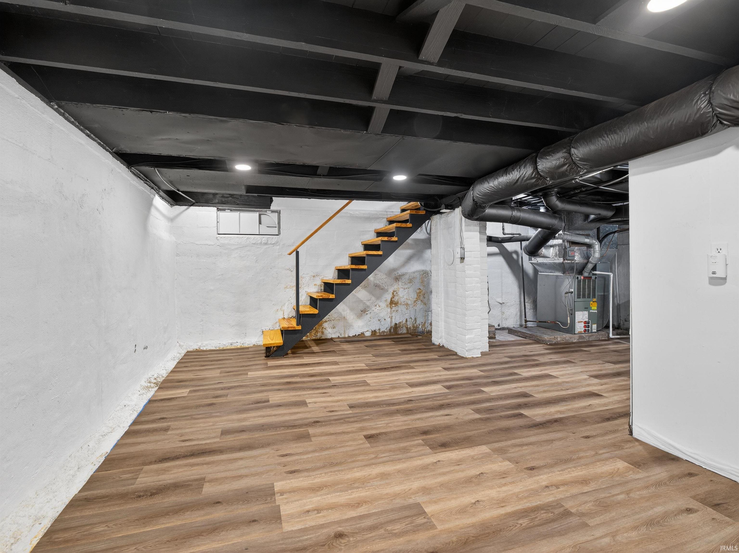 Below grade area with wood finished floors and heating unit