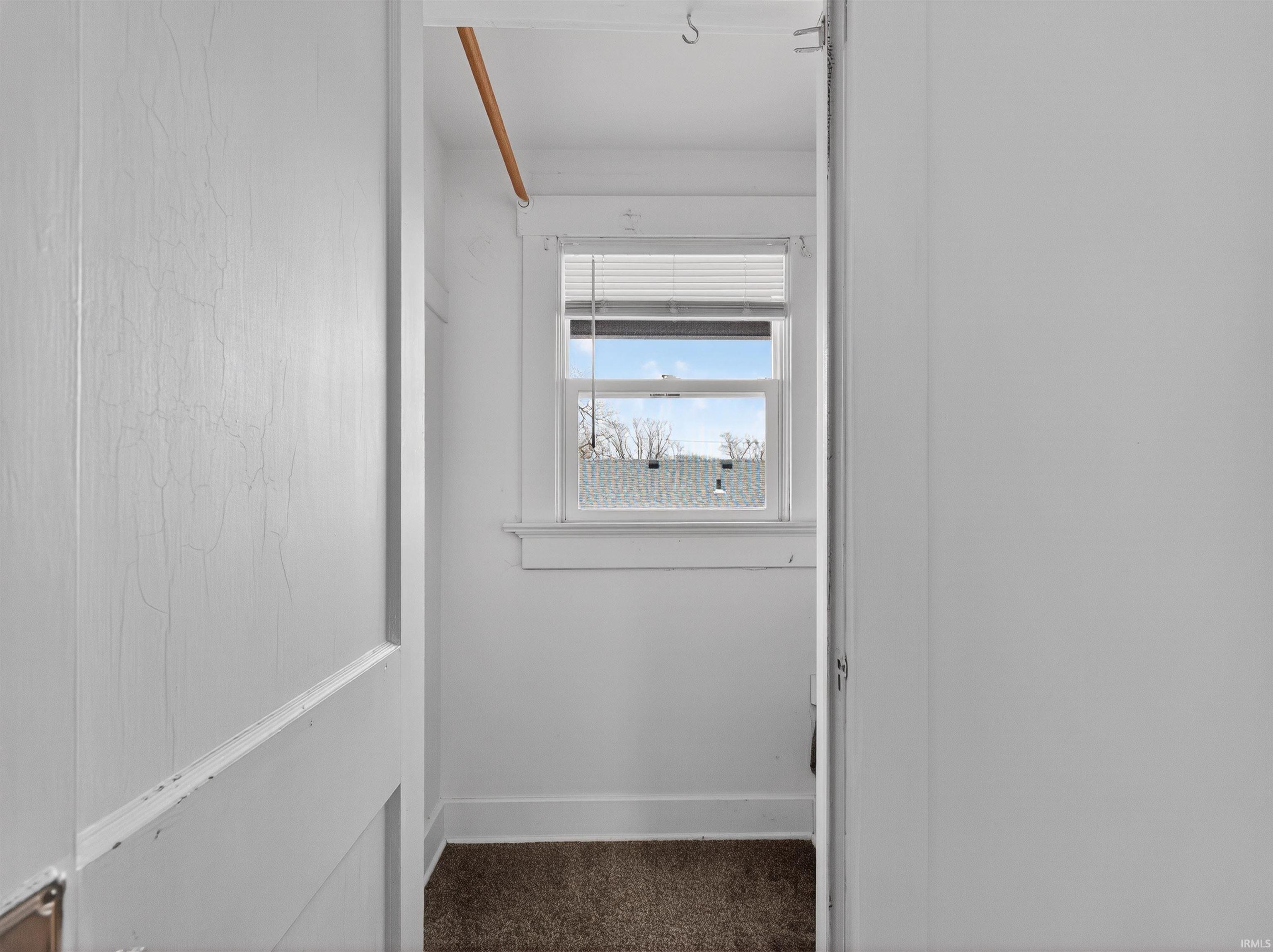 Corridor with dark carpet and baseboards