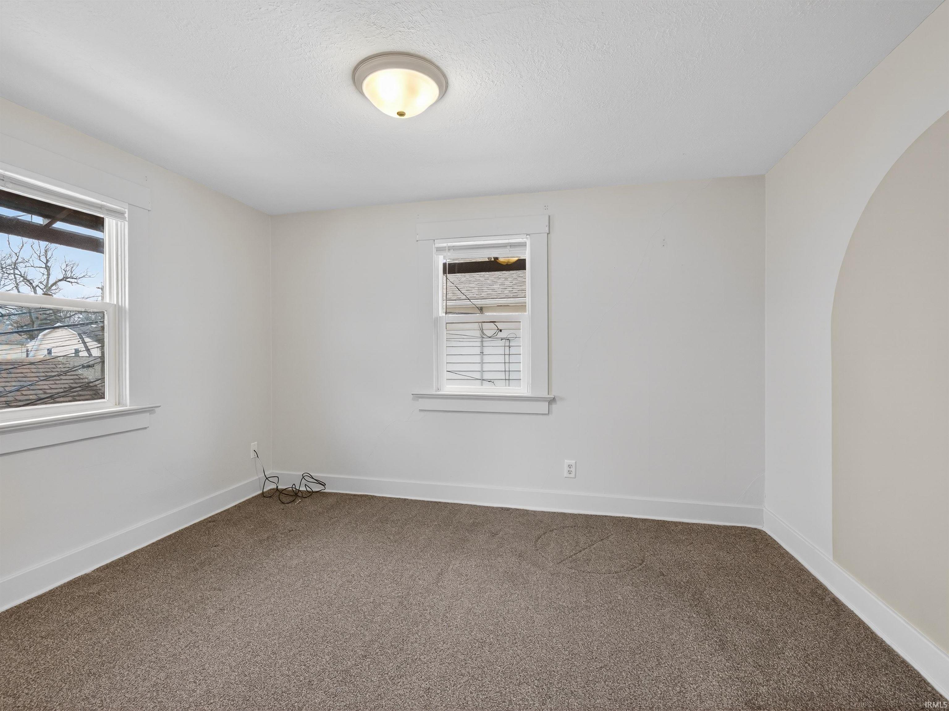 Spare room featuring carpet and a textured ceiling