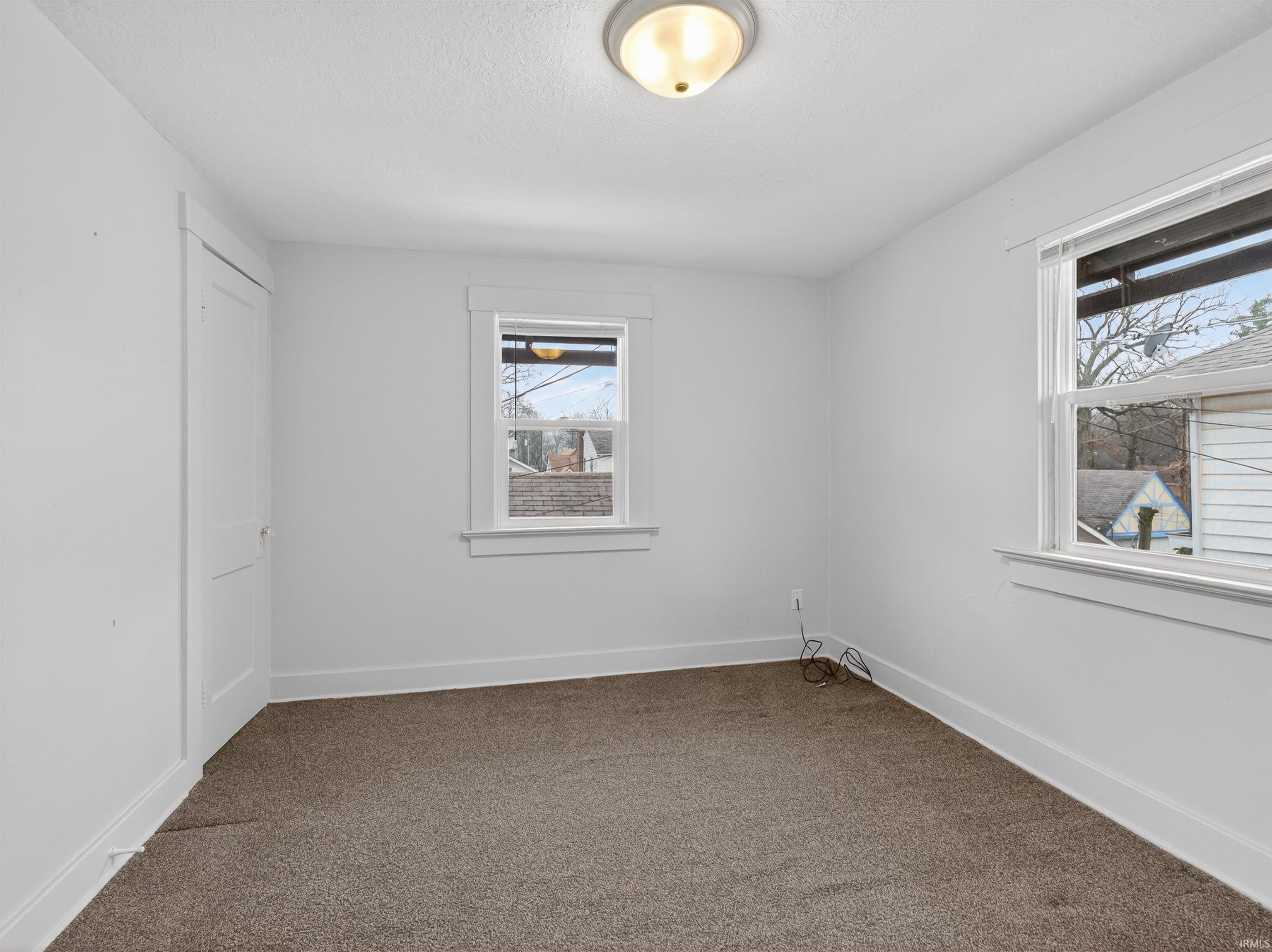 Spare room with baseboards and carpet