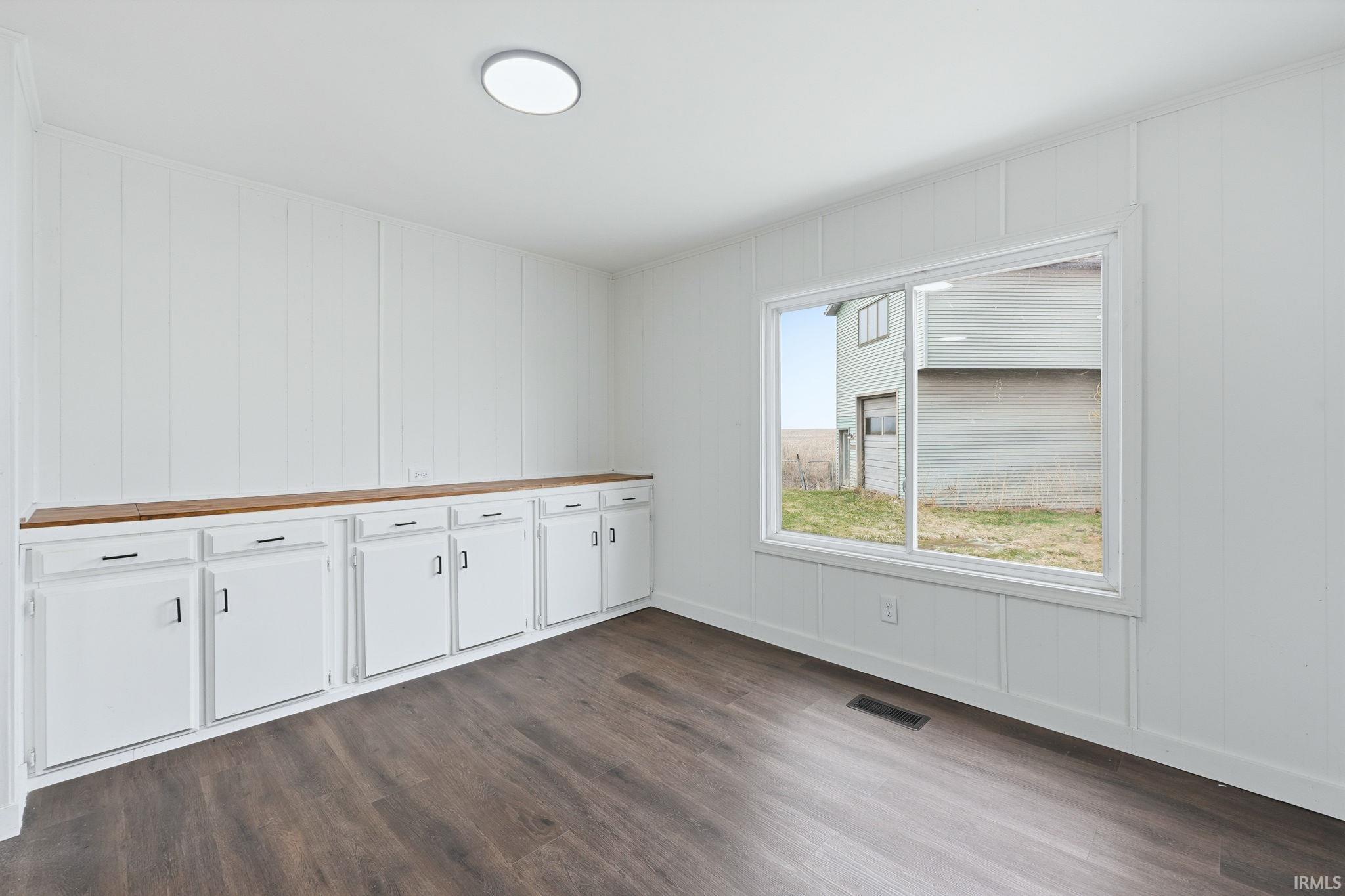 Unfurnished room with dark wood-style flooring and baseboards