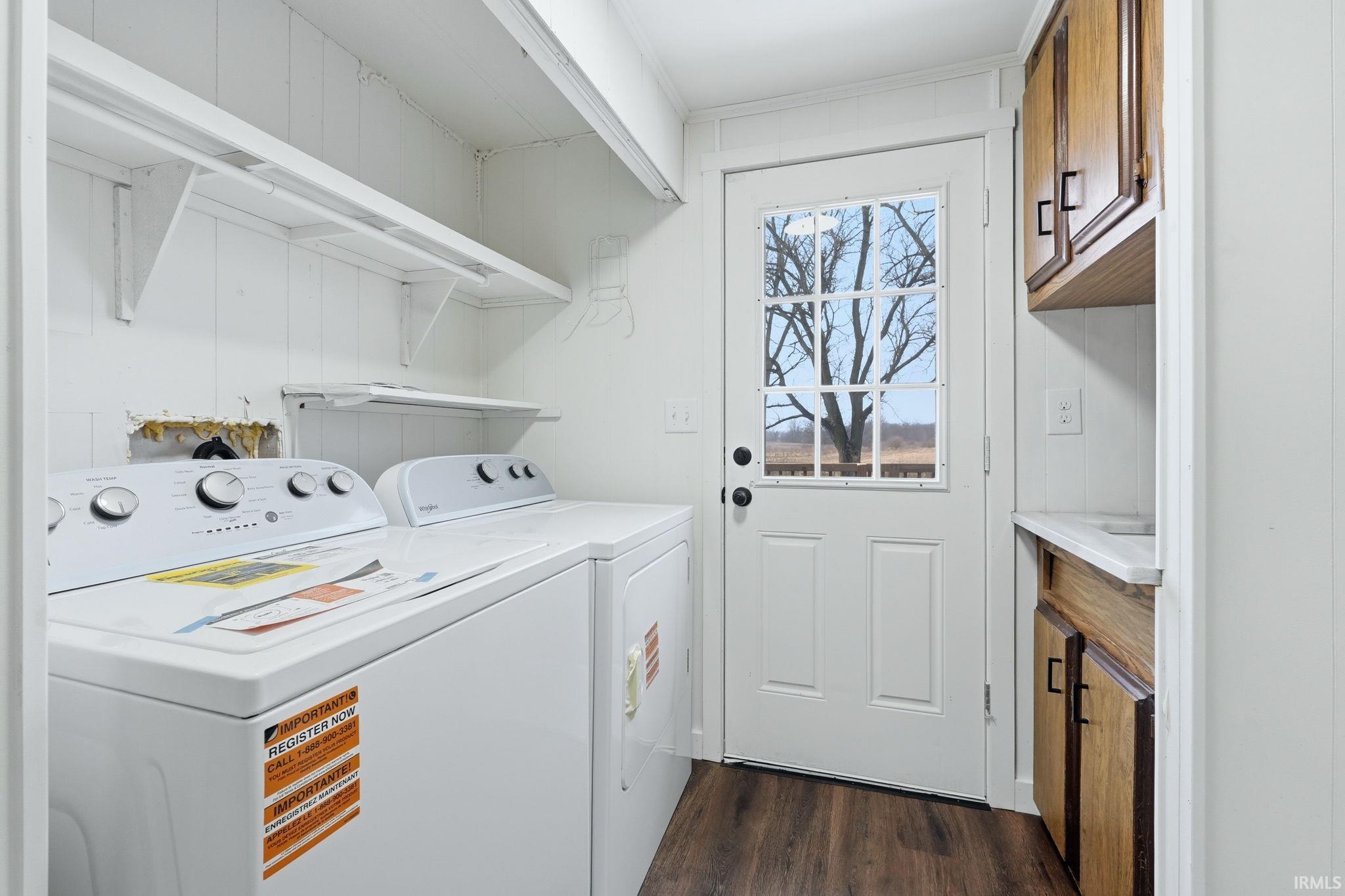 Laundry area featuring dark wood finished floors and separate washer and dryer